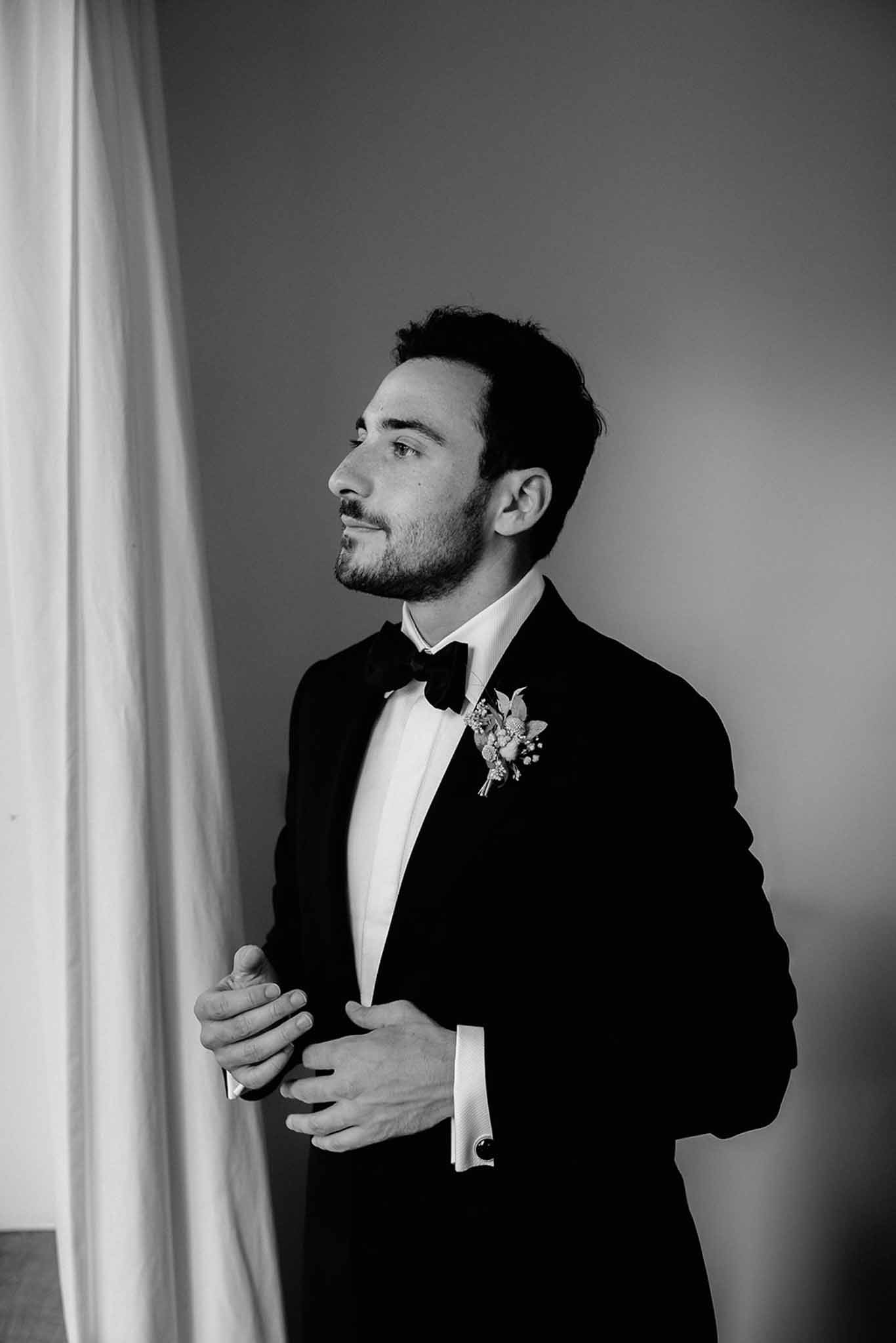 Groom holding his suit jacket in a beauty shot, black and white photograph at Dîme de Giverny