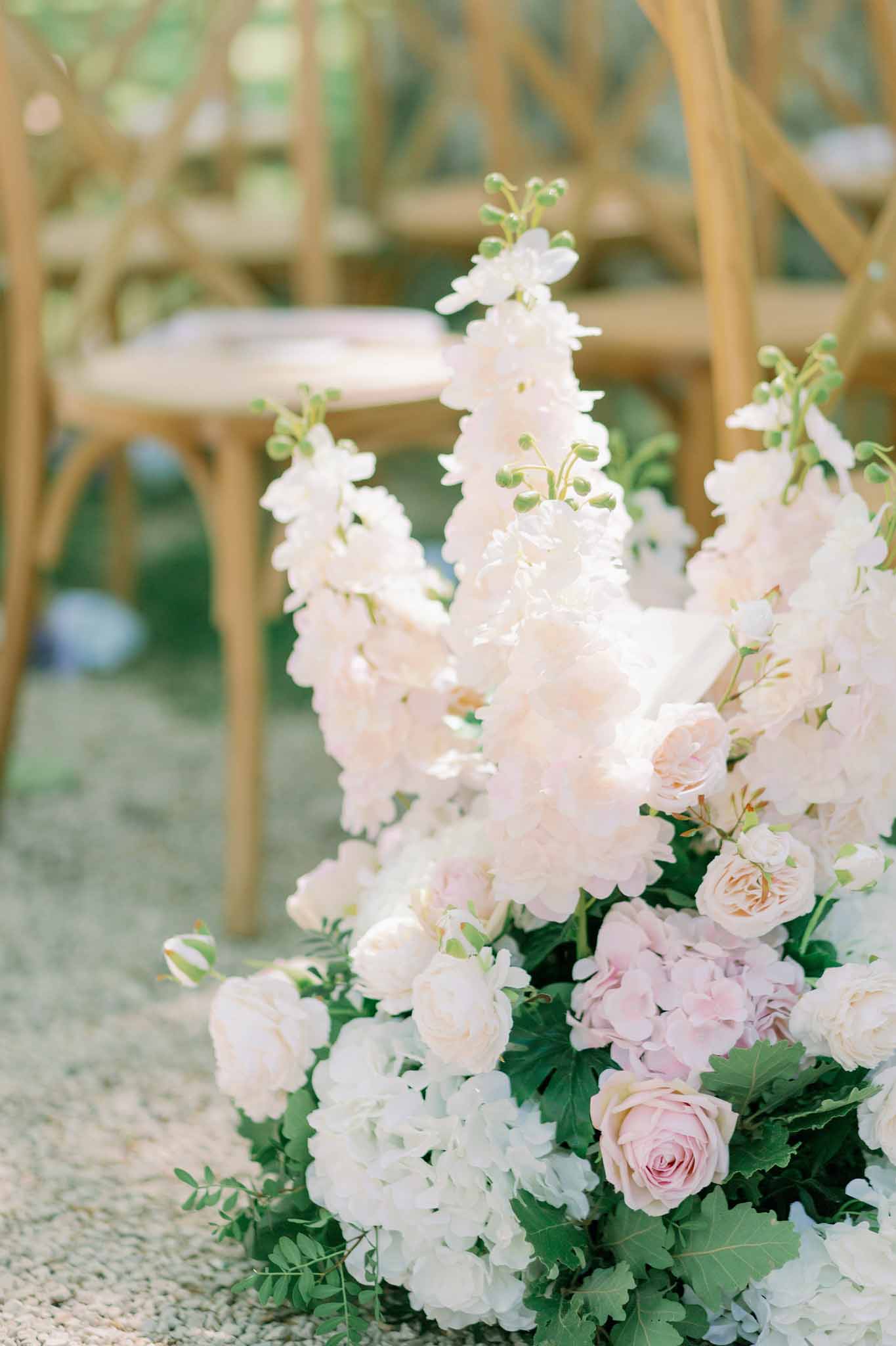 White flower arrangements lining the ceremony aisle at wedding venue