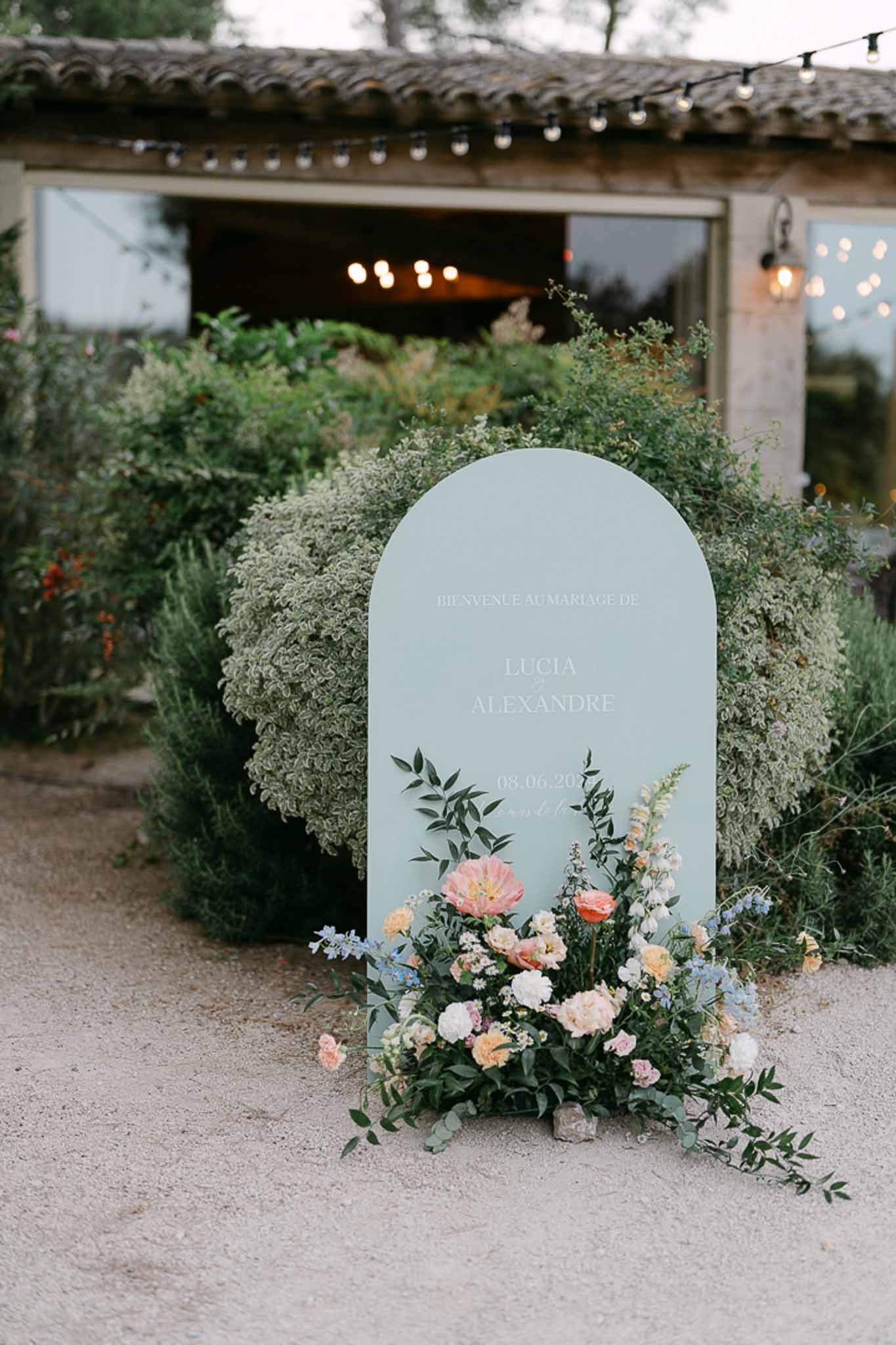 Round strawberry wedding cake being cut at outdoor reception at Mas de la Rose photographed by K Flament