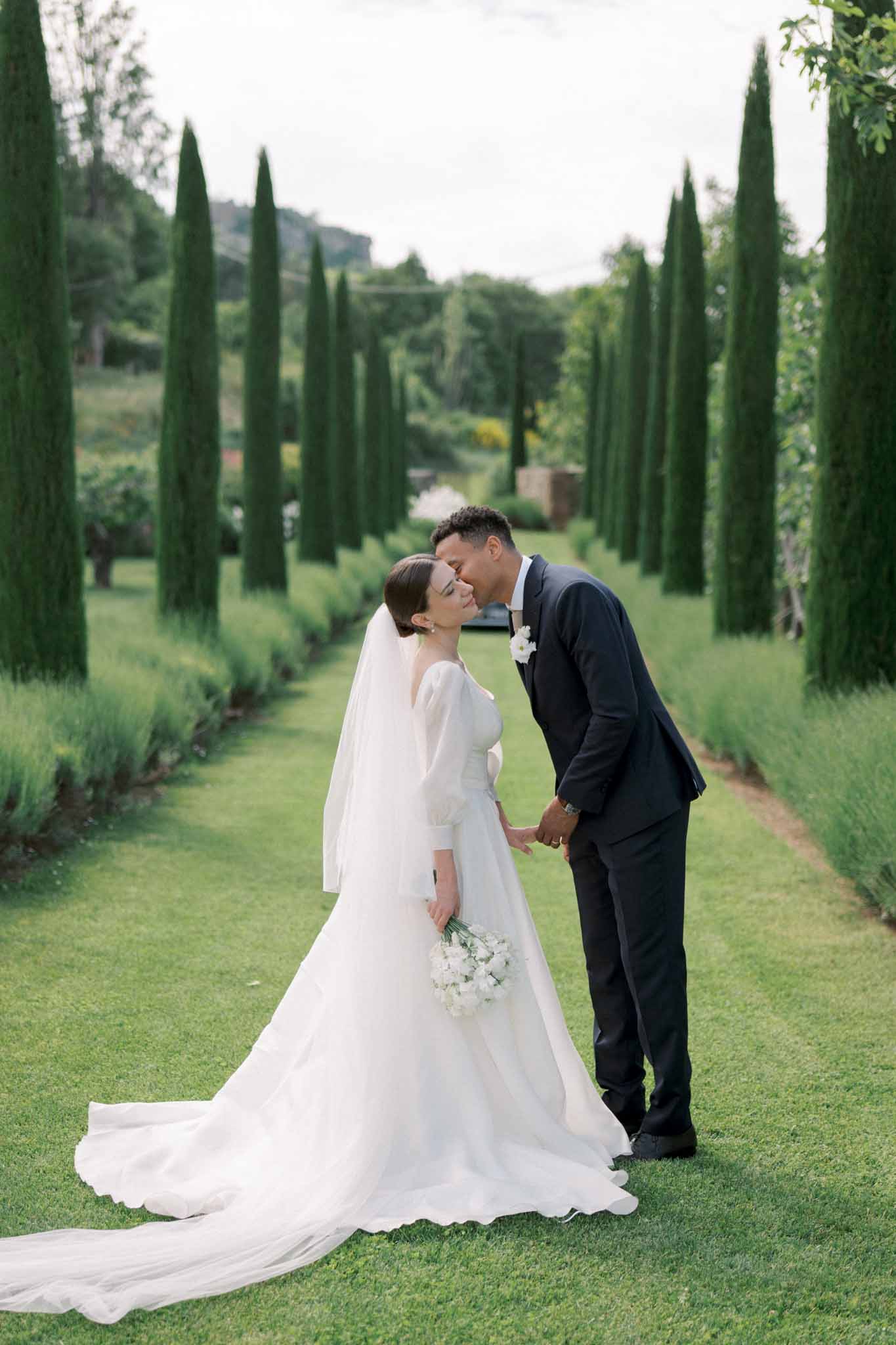Bride and groom kissing in a garden