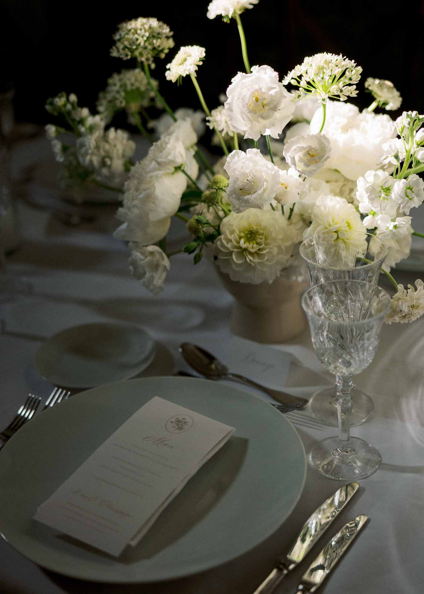 Wedding reception table setting in a garden with white roses