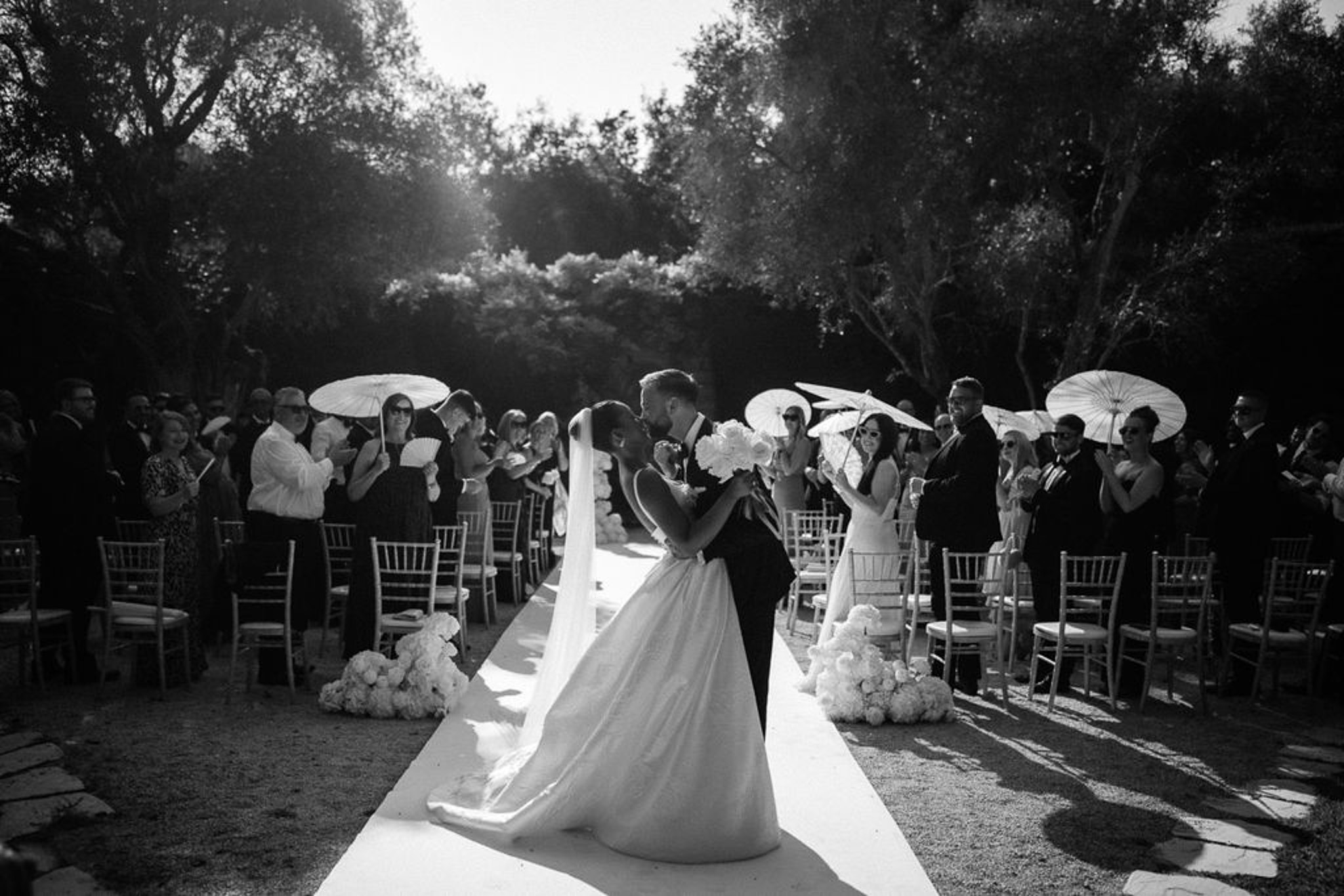 Wedding ceremony recessional with bride and groom walking down aisle in outdoor garden setting