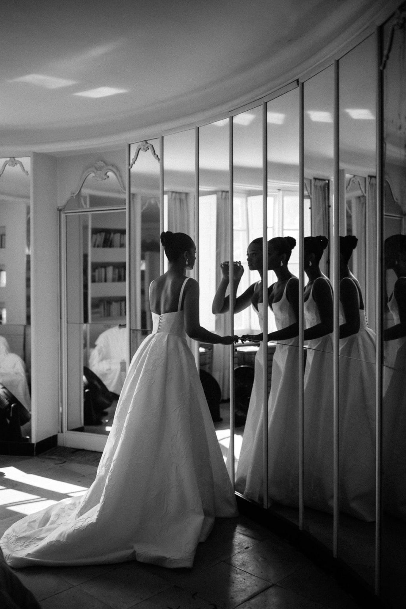 Bride in ball gown getting ready in mirrored dressing room with multiple reflections
