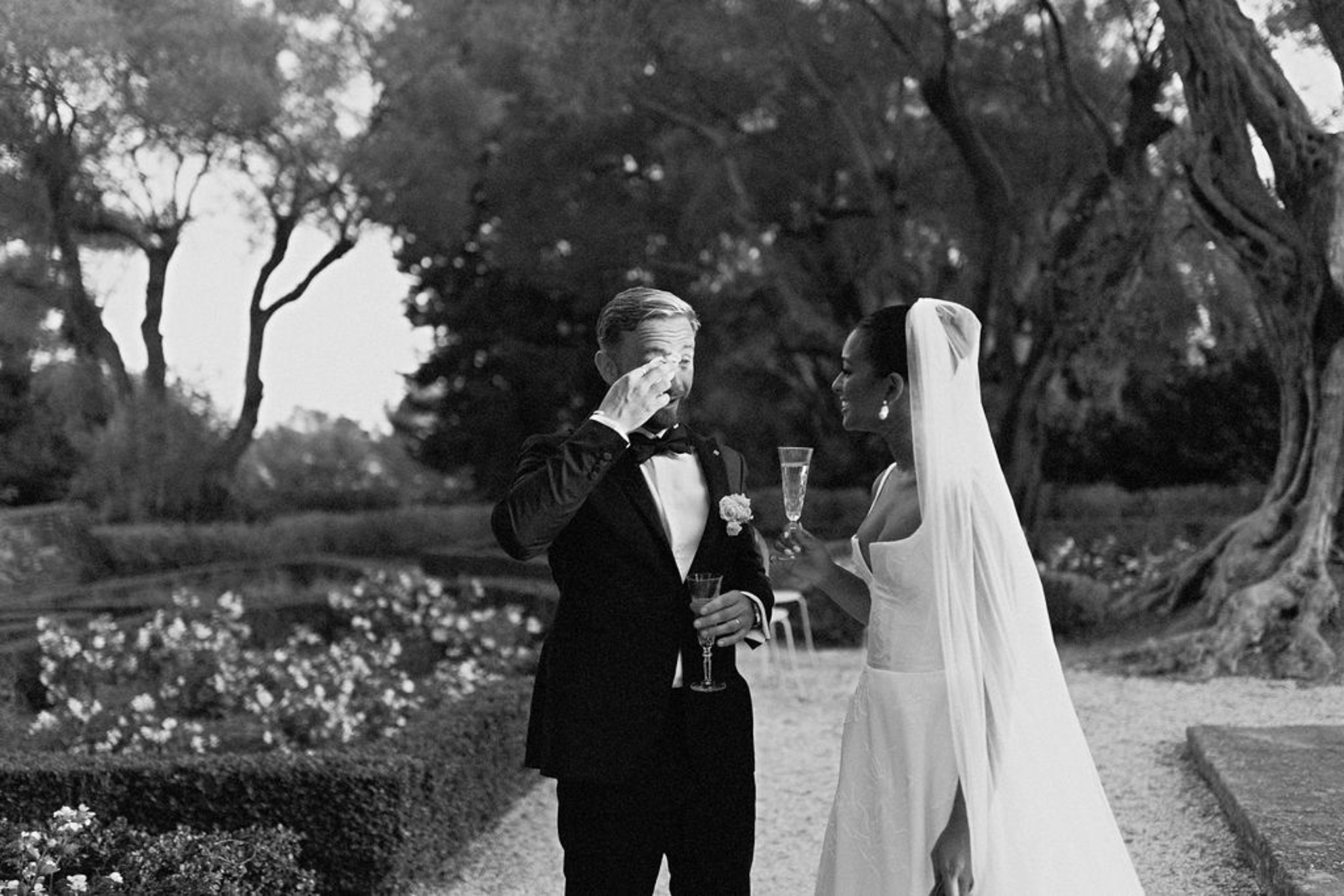 Black and white photo of wedding ceremony in a garden with white roses
