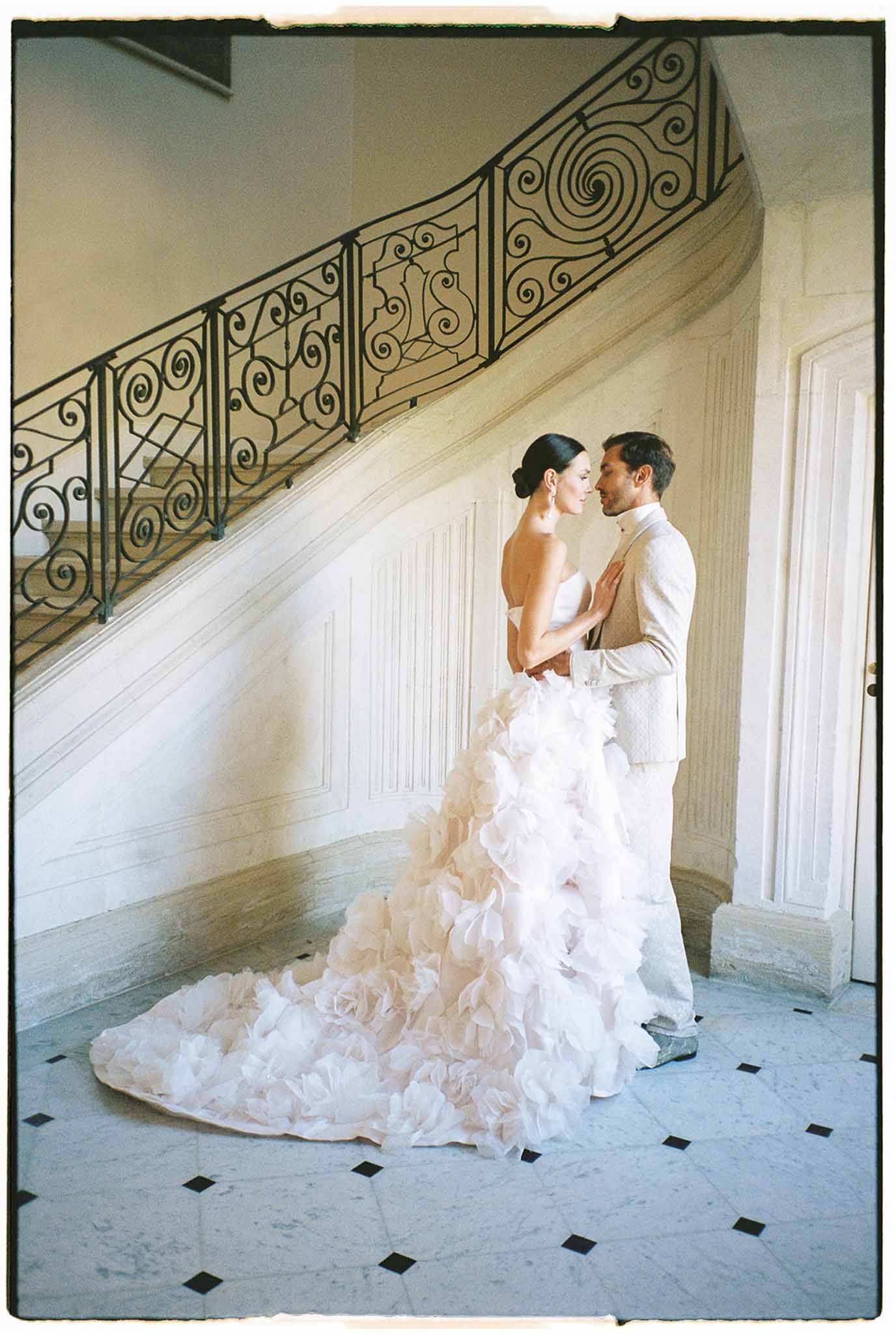 Bride and groom intimate portrait in classical interior hallway with marble floors