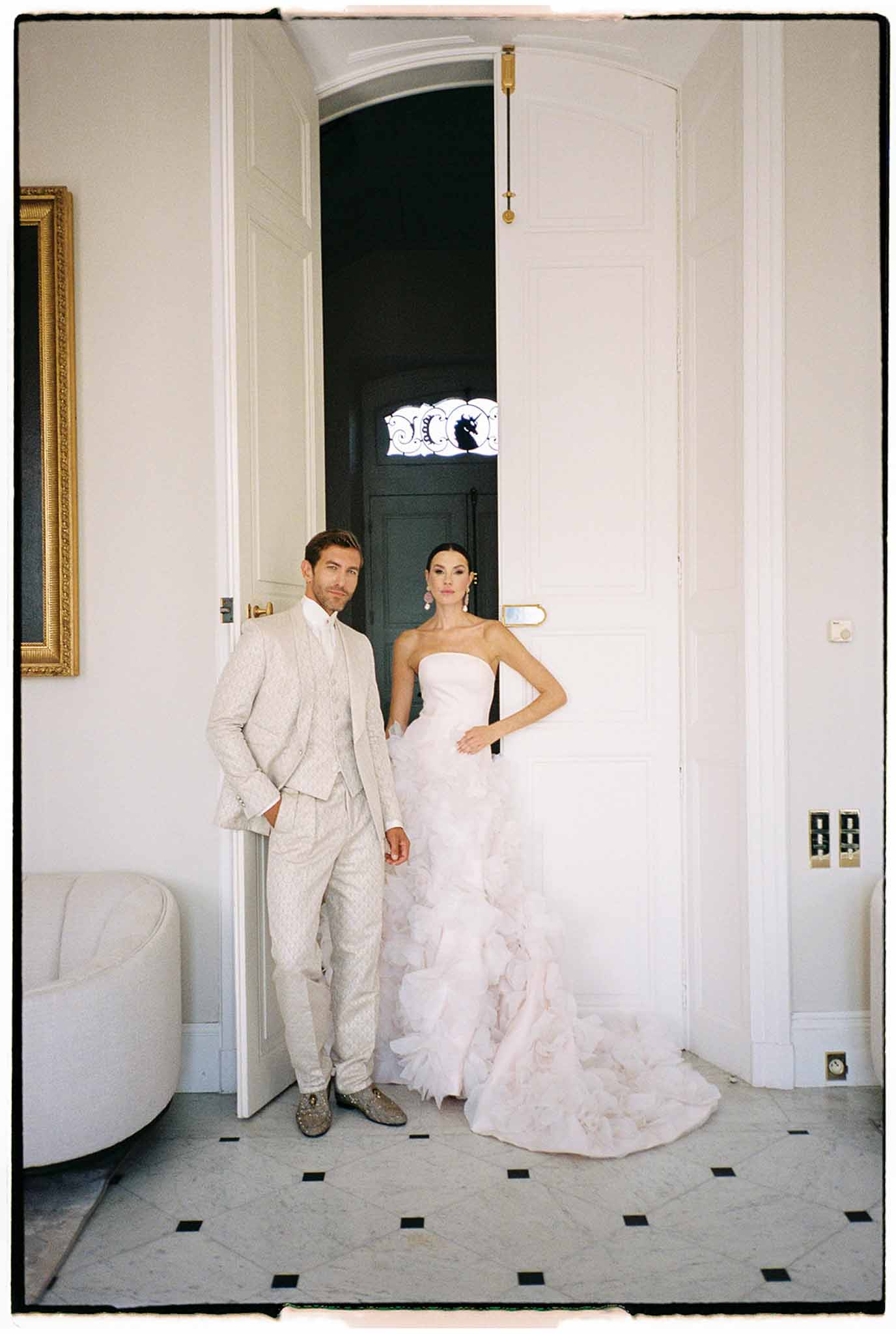 Bride and groom formal portrait in elegant hallway with checkered floor and classical architectural details