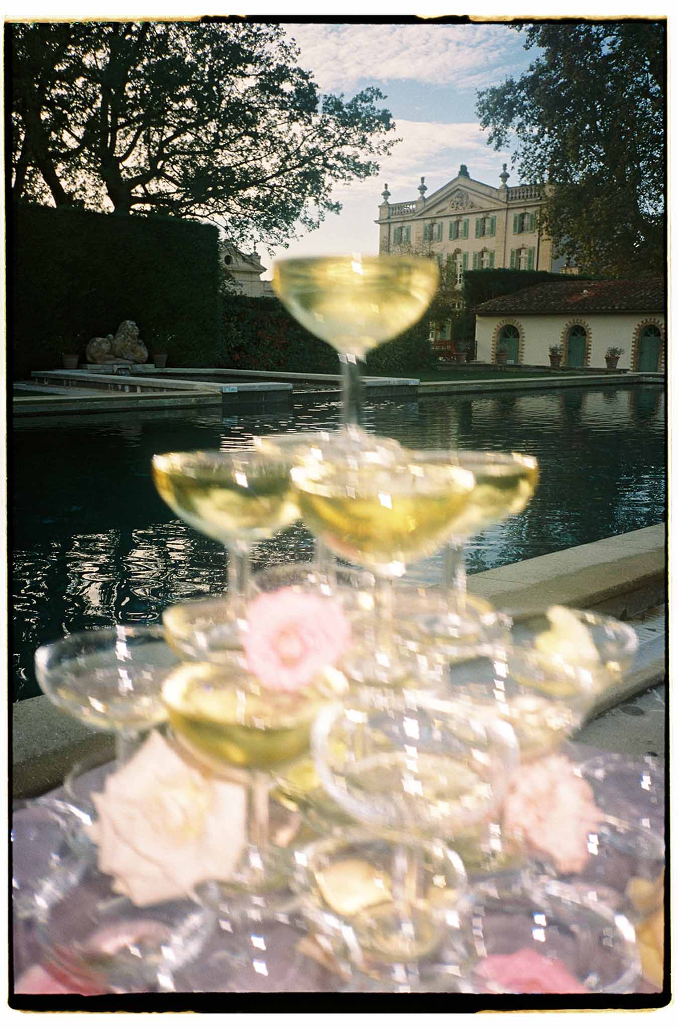 Wine glasses and pink roses at Italian villa cocktail hour with canal view