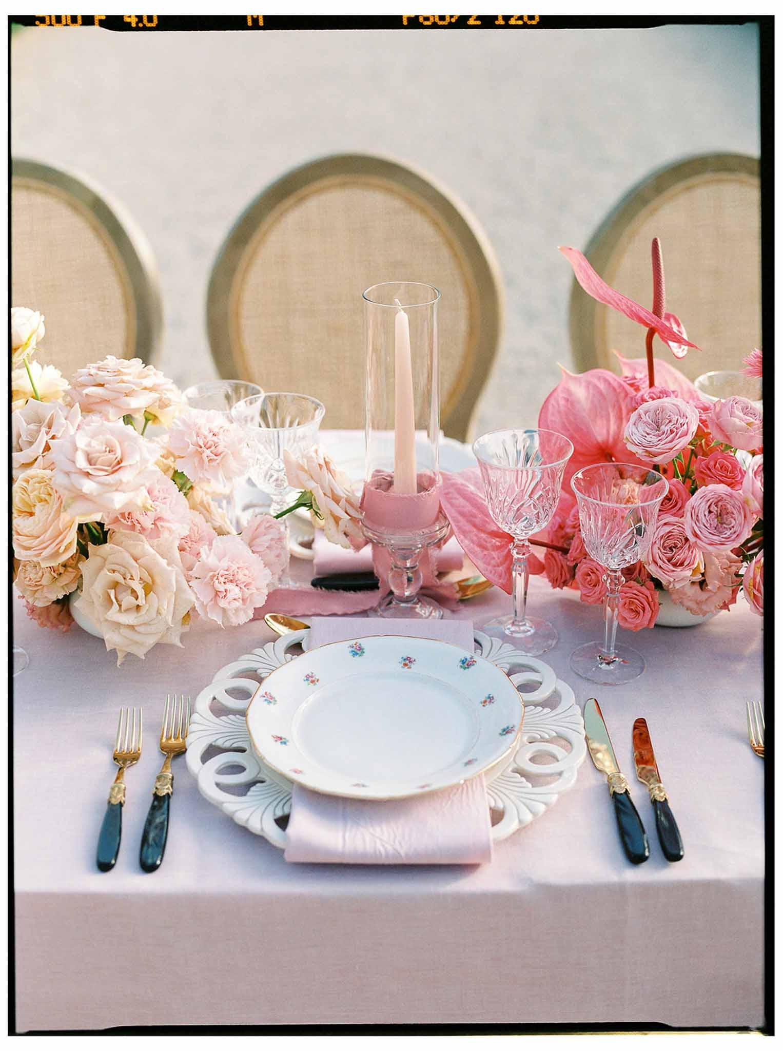 Elegant table setting with floral centerpiece and gold accents at wedding reception
