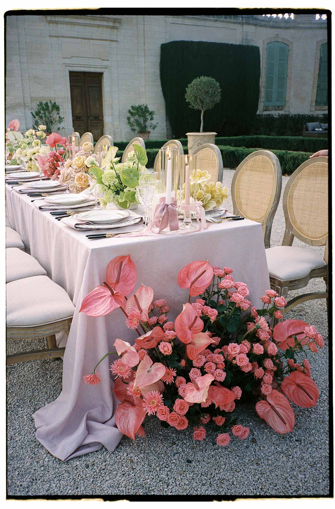 Reception table setting with coral florals in classical courtyard venue