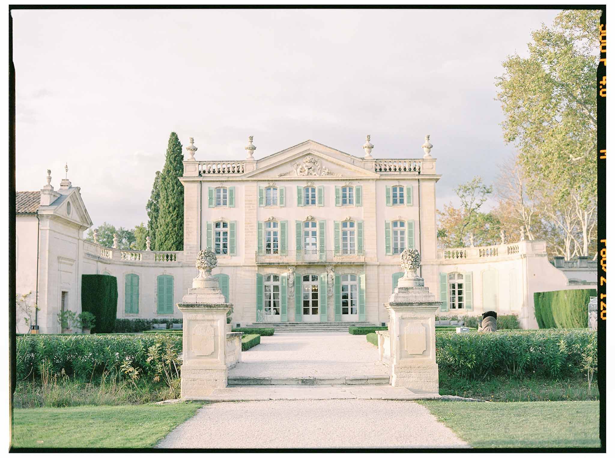 Neoclassical château with formal gardens and manicured hedges at French wedding venue