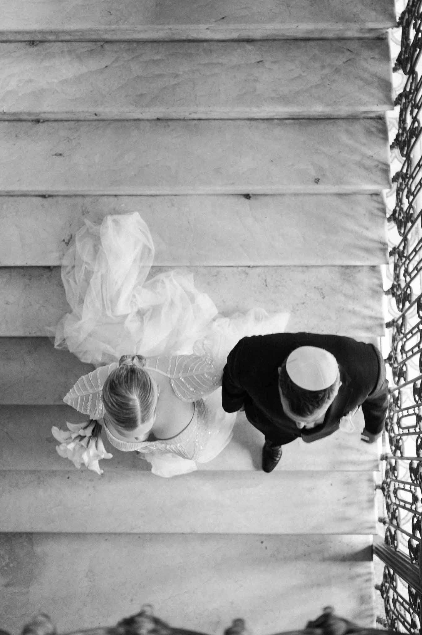 Bride and groom descending grand staircase shot from above in black and white