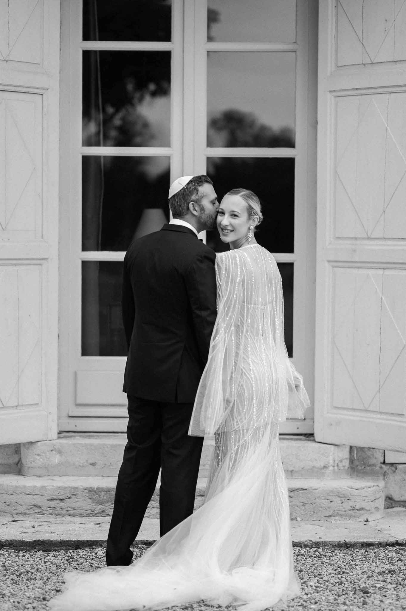 Bride and groom portrait in front of classical white building with neoclassical facade