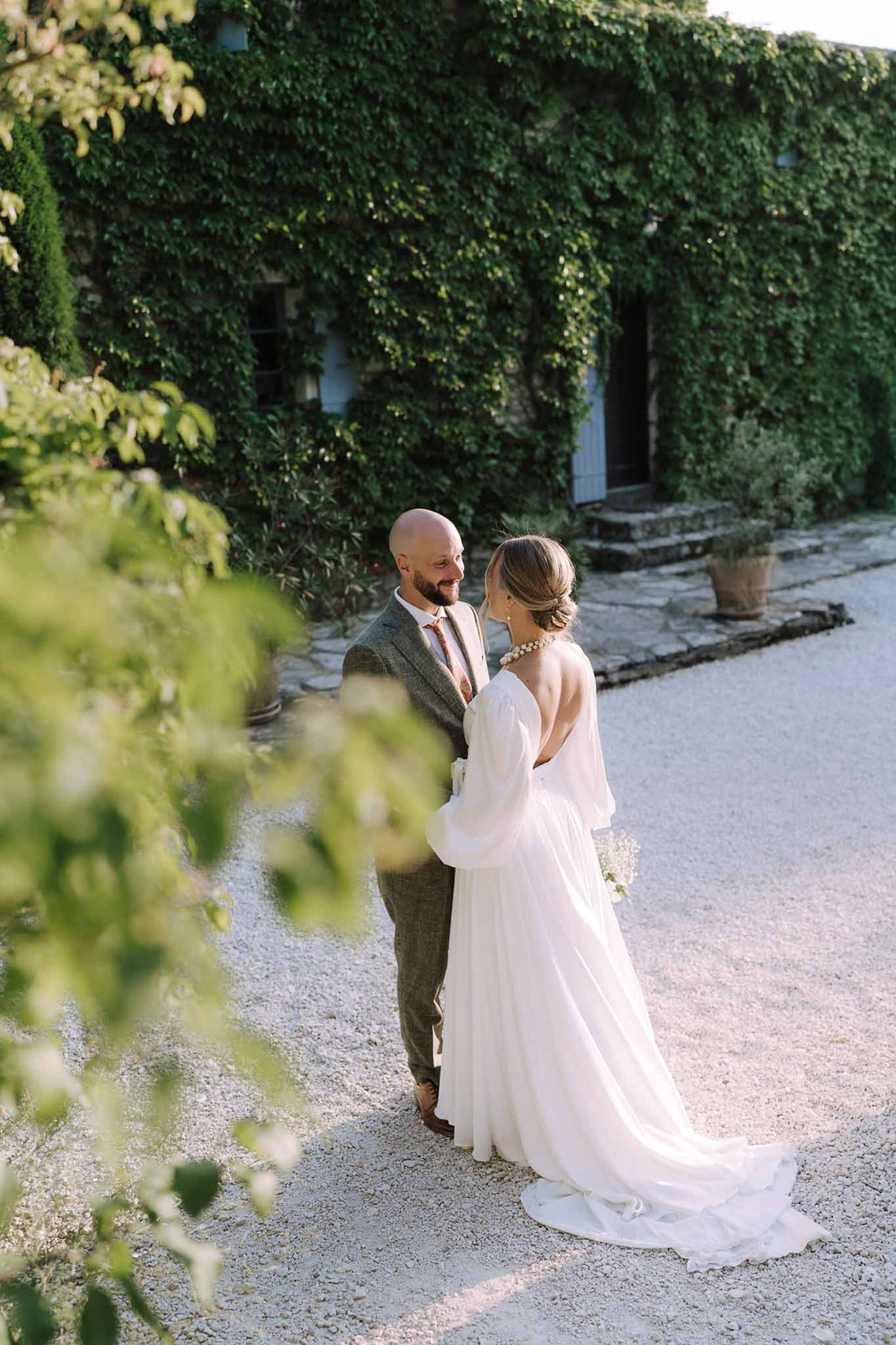 Bride and groom portrait in ivy-covered stone courtyard at European villa wedding venue