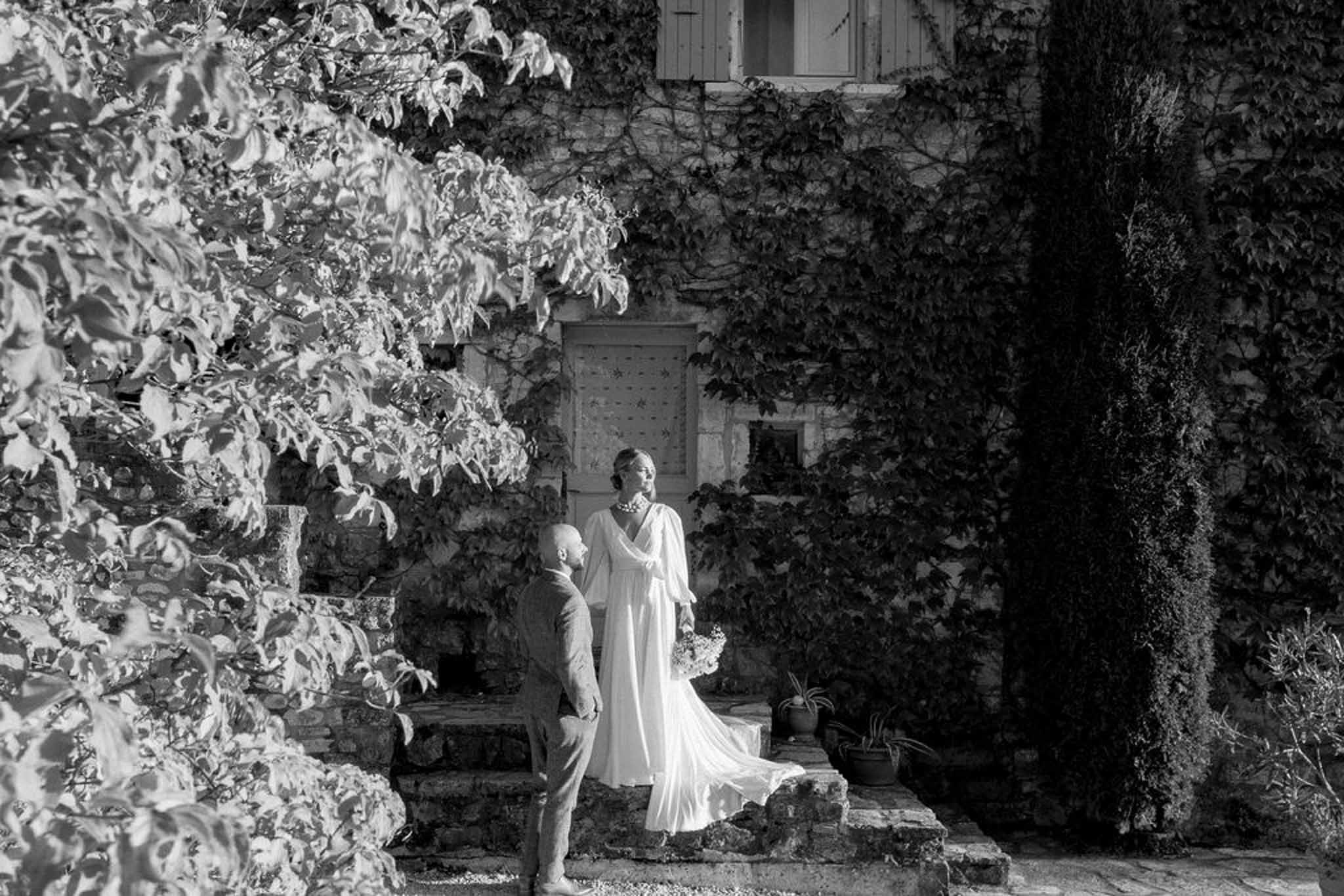 Bride and groom portrait in ivy-covered stone courtyard garden passage