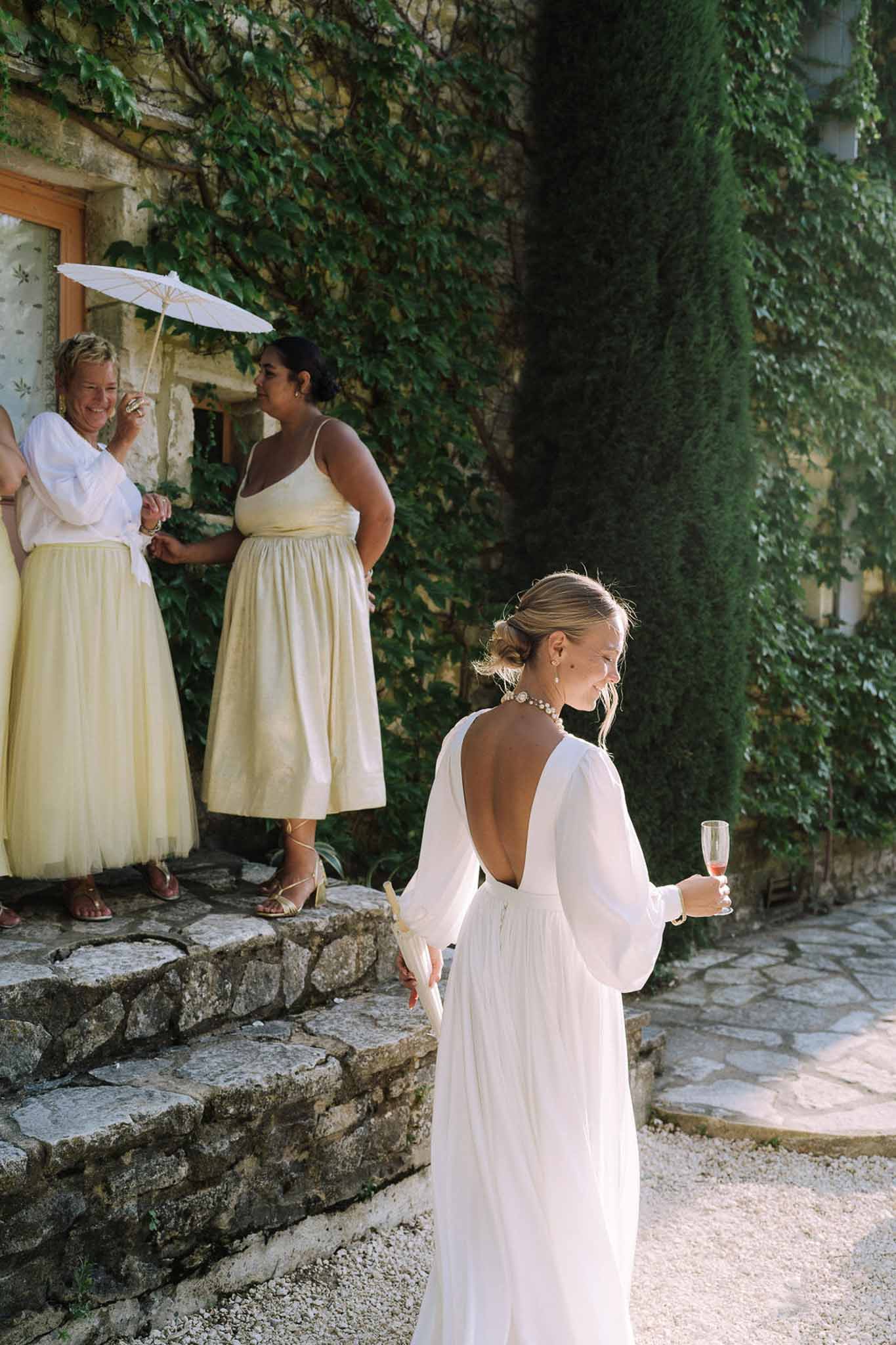 Bride and bridesmaids in ivy-covered stone courtyard at Mediterranean wedding venue