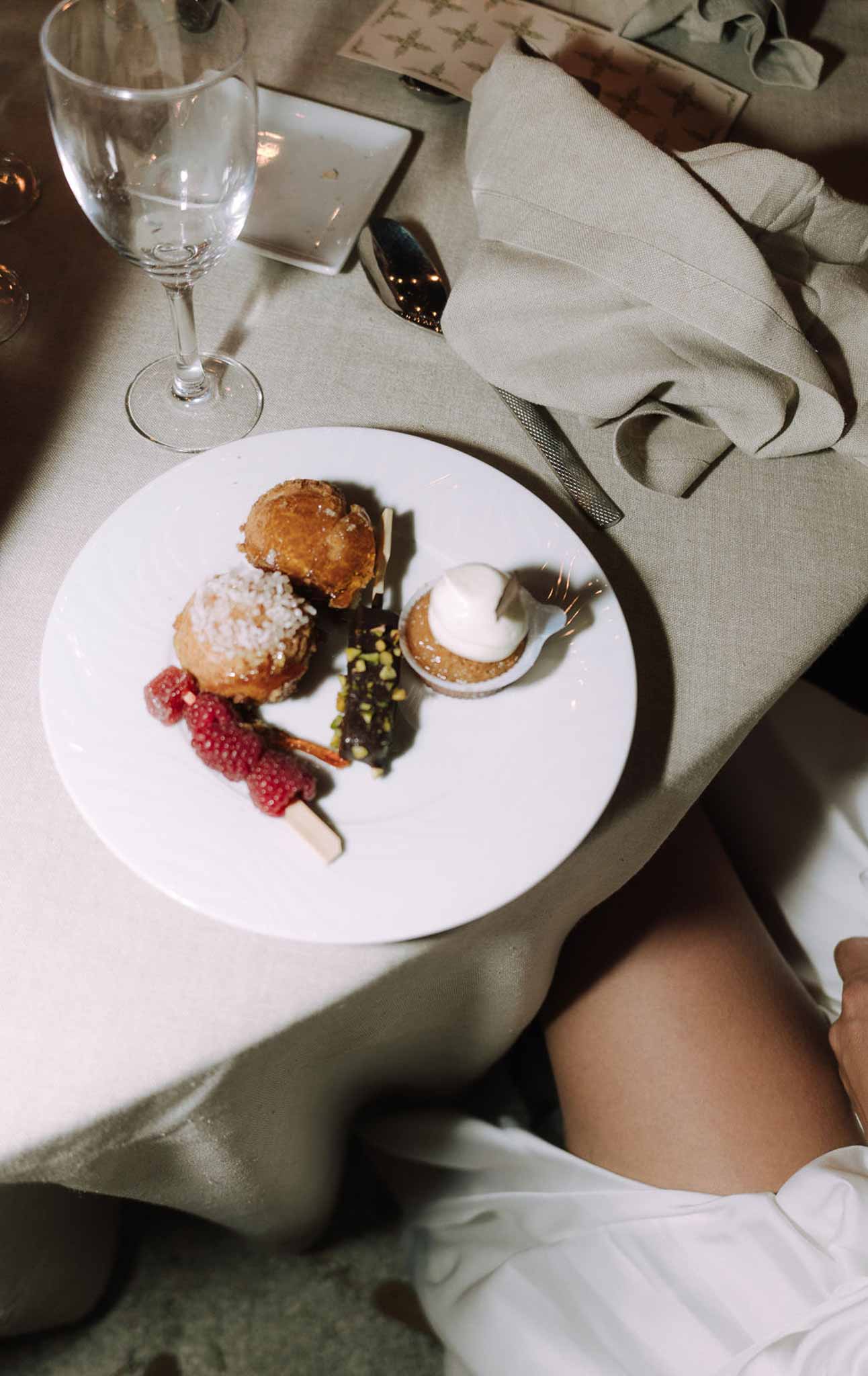 Plated dessert course with pastries and raspberries at wedding reception dinner table