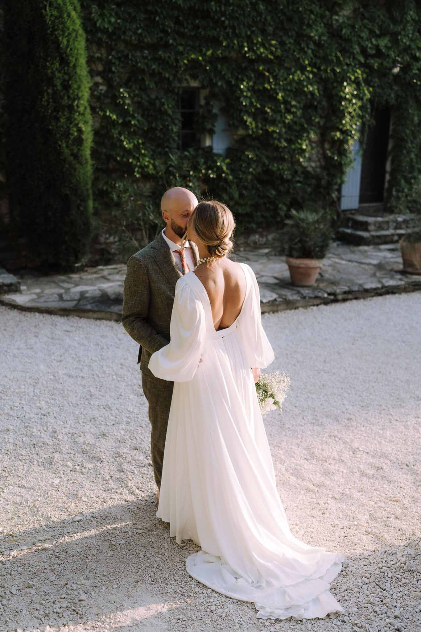 Couple portrait in ivy-covered stone courtyard at European villa