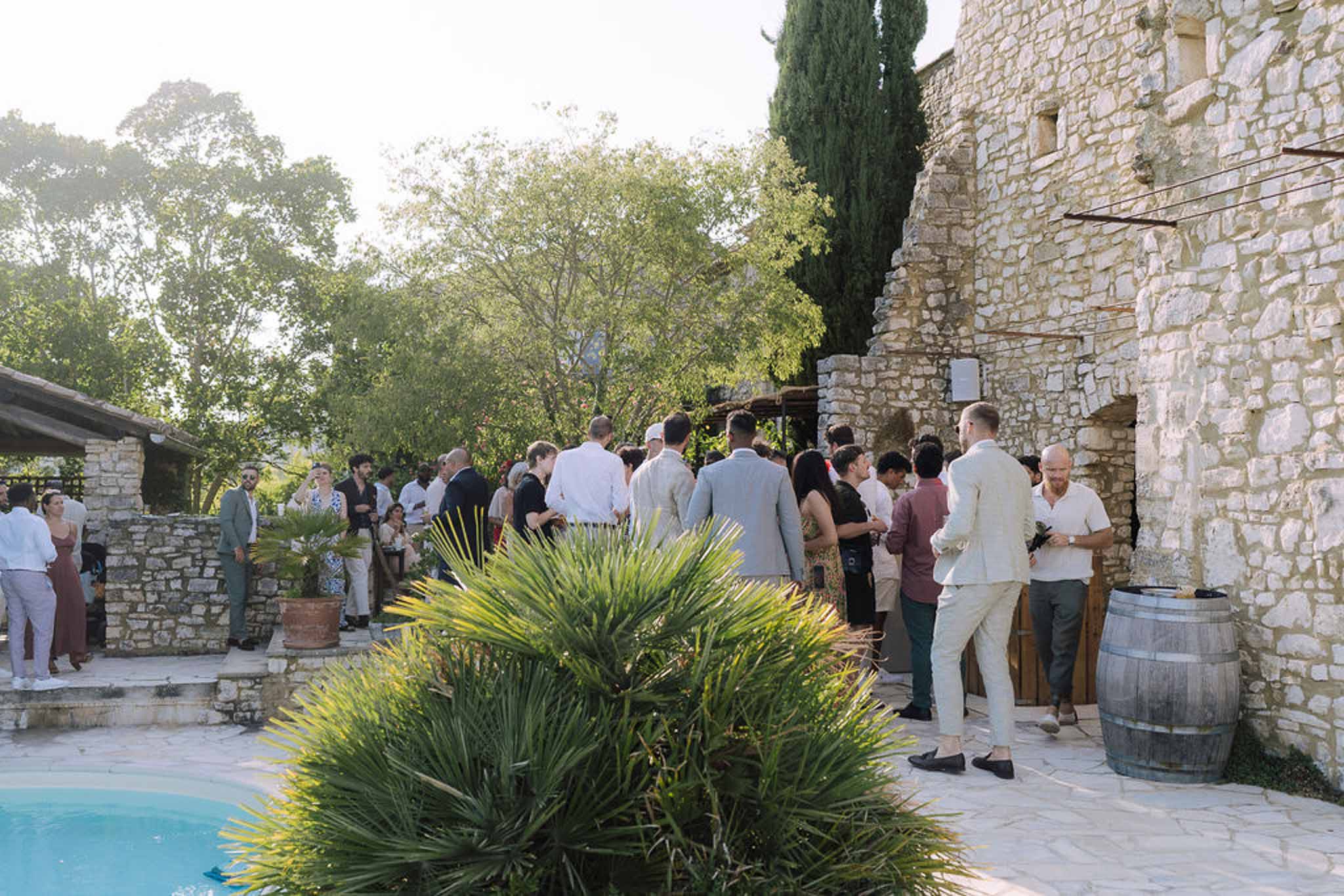 Cocktail hour guests mingling in outdoor stone courtyard at Mediterranean-style wedding venue