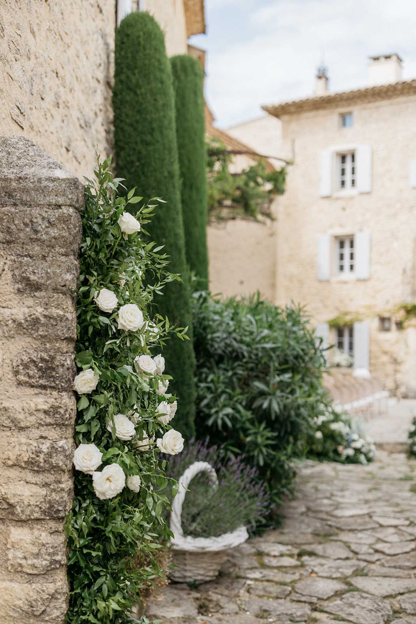 Ivory rose garland decorating stone courtyard wall at European countryside estate