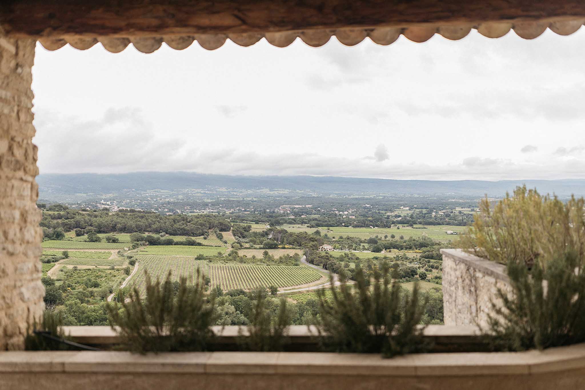 Stone archway framing vineyard landscape at wedding venue with terrace and rolling hills