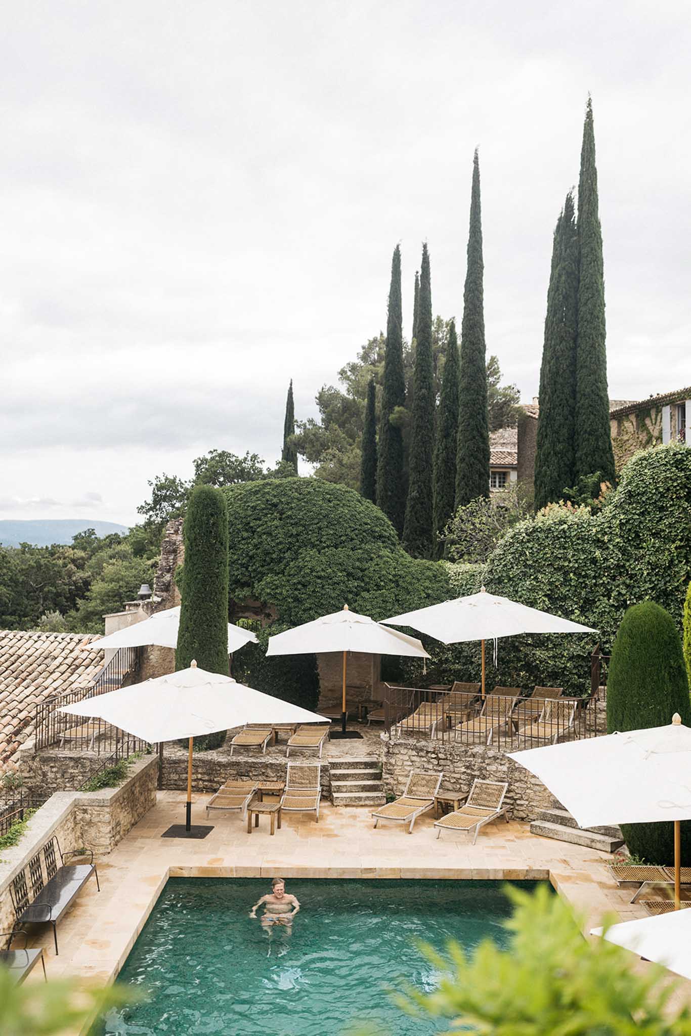 Aerial view of poolside terrace at Tuscan villa wedding venue with swimming pool and umbrellas