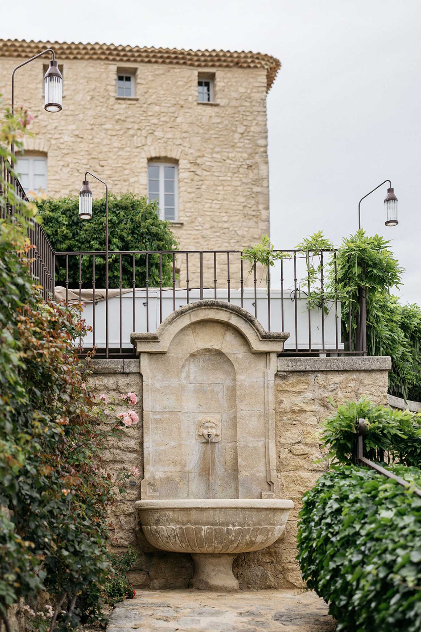 Stone fountain courtyard with terracotta roof and ivy at historic European estate venue