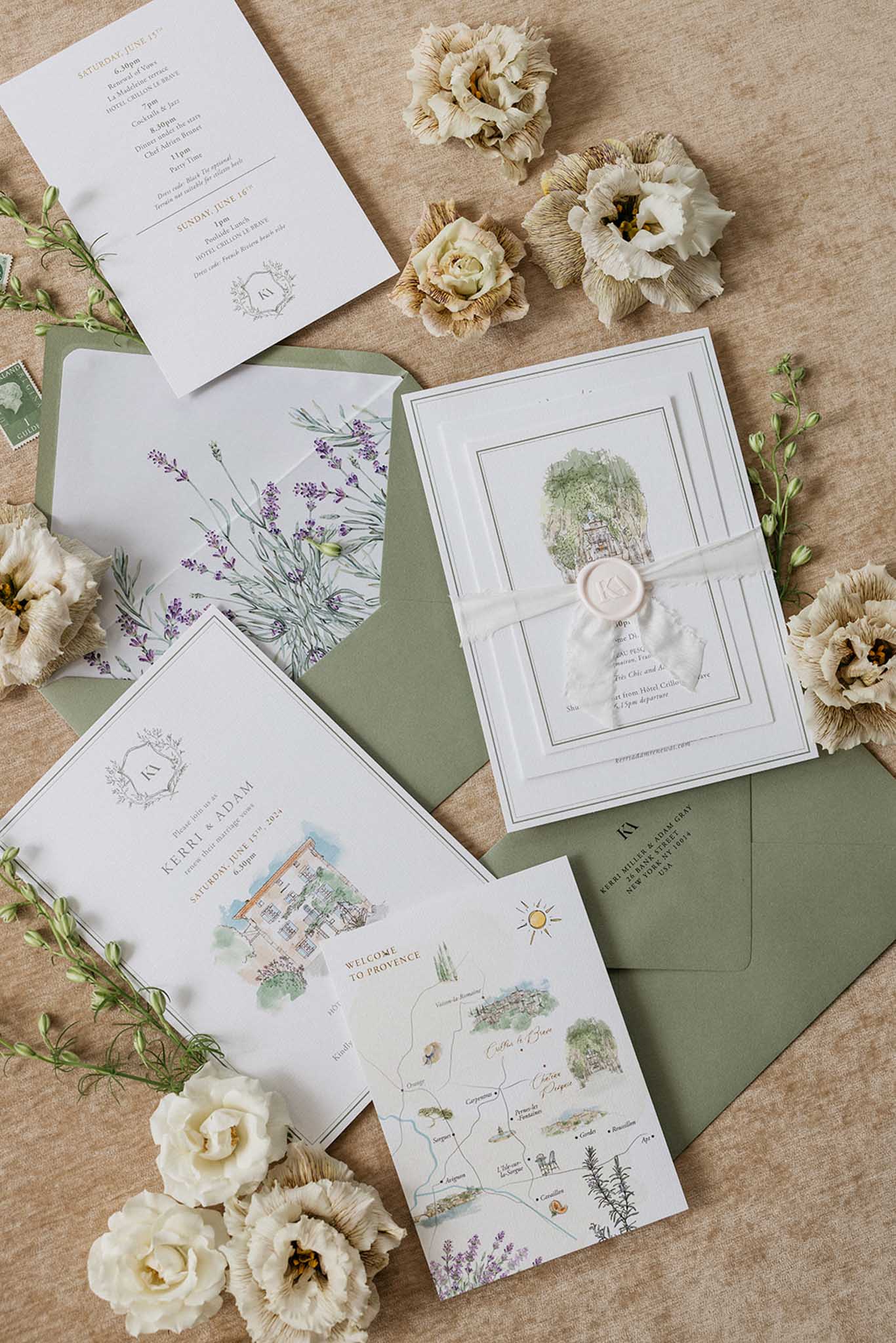 Wedding invitation suite with botanical illustrations and cream roses arranged on linen surface