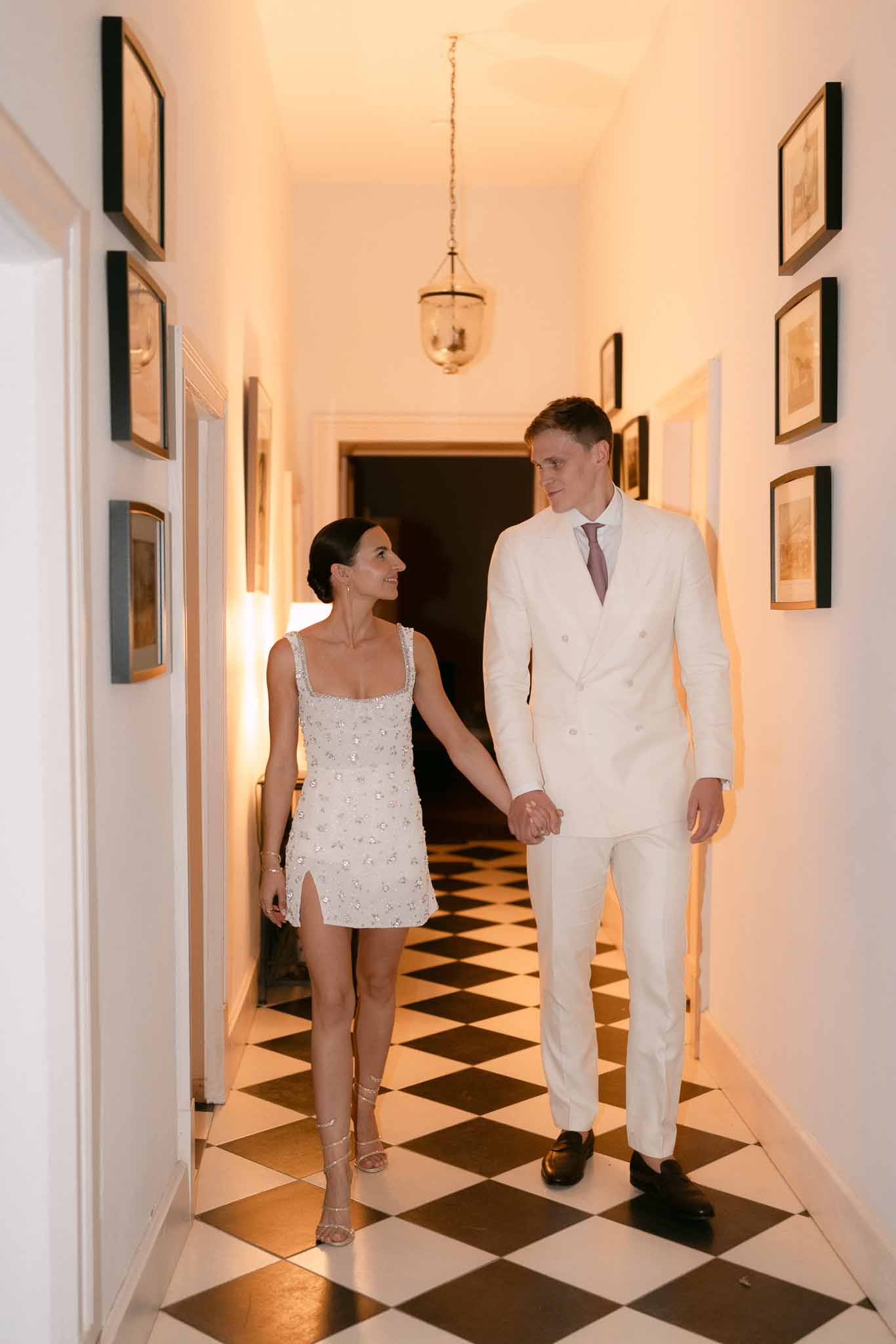Black and white photo of bride and groom walking hand in hand