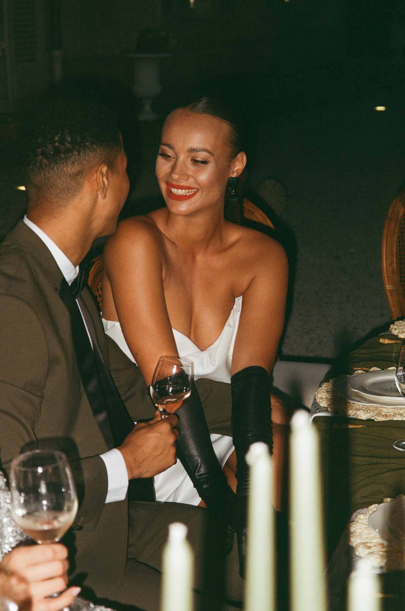 Bride and groom sharing intimate moment during reception dinner at indoor wedding venue