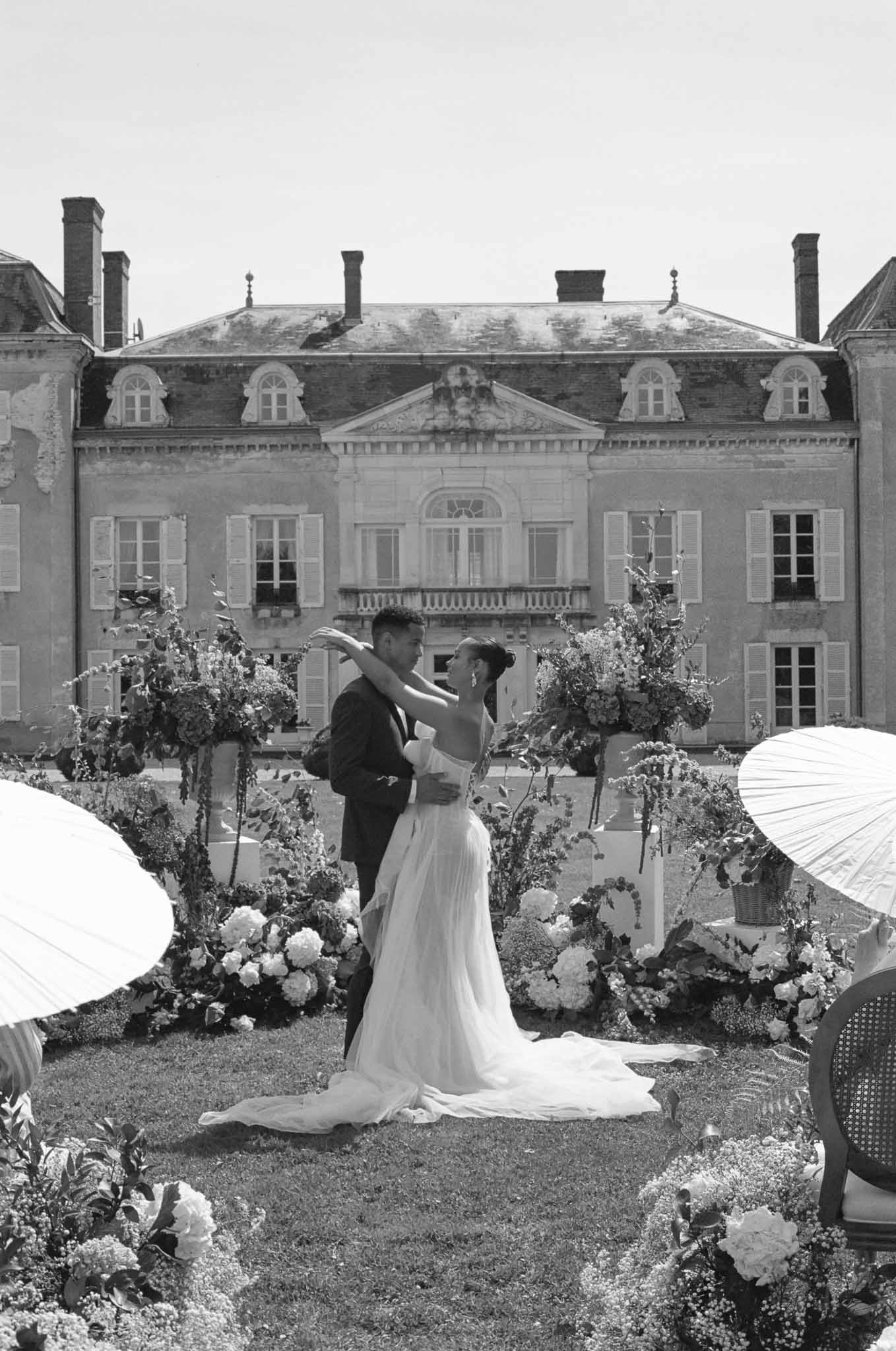 Couple's first dance in formal garden courtyard at historic stone mansion