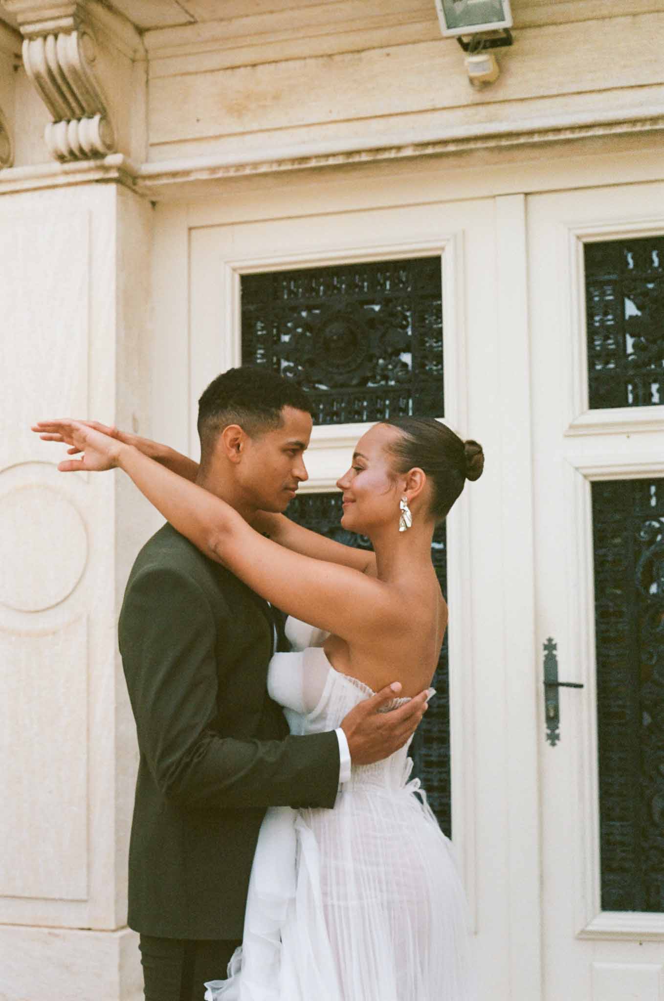Couple sharing intimate moment during portrait session in modern indoor venue with cream walls