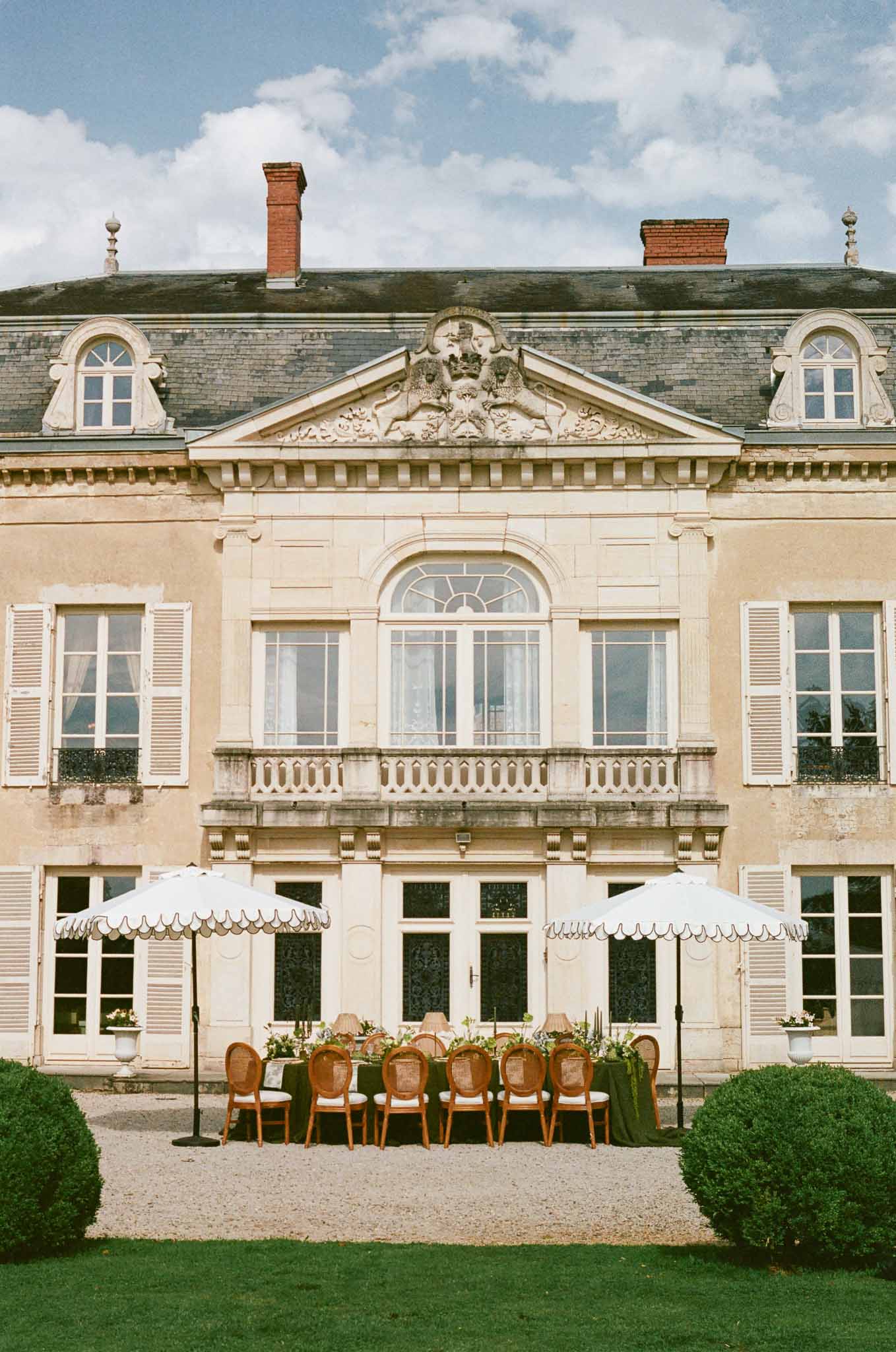 Outdoor reception table setup in courtyard of French château with classical architecture
