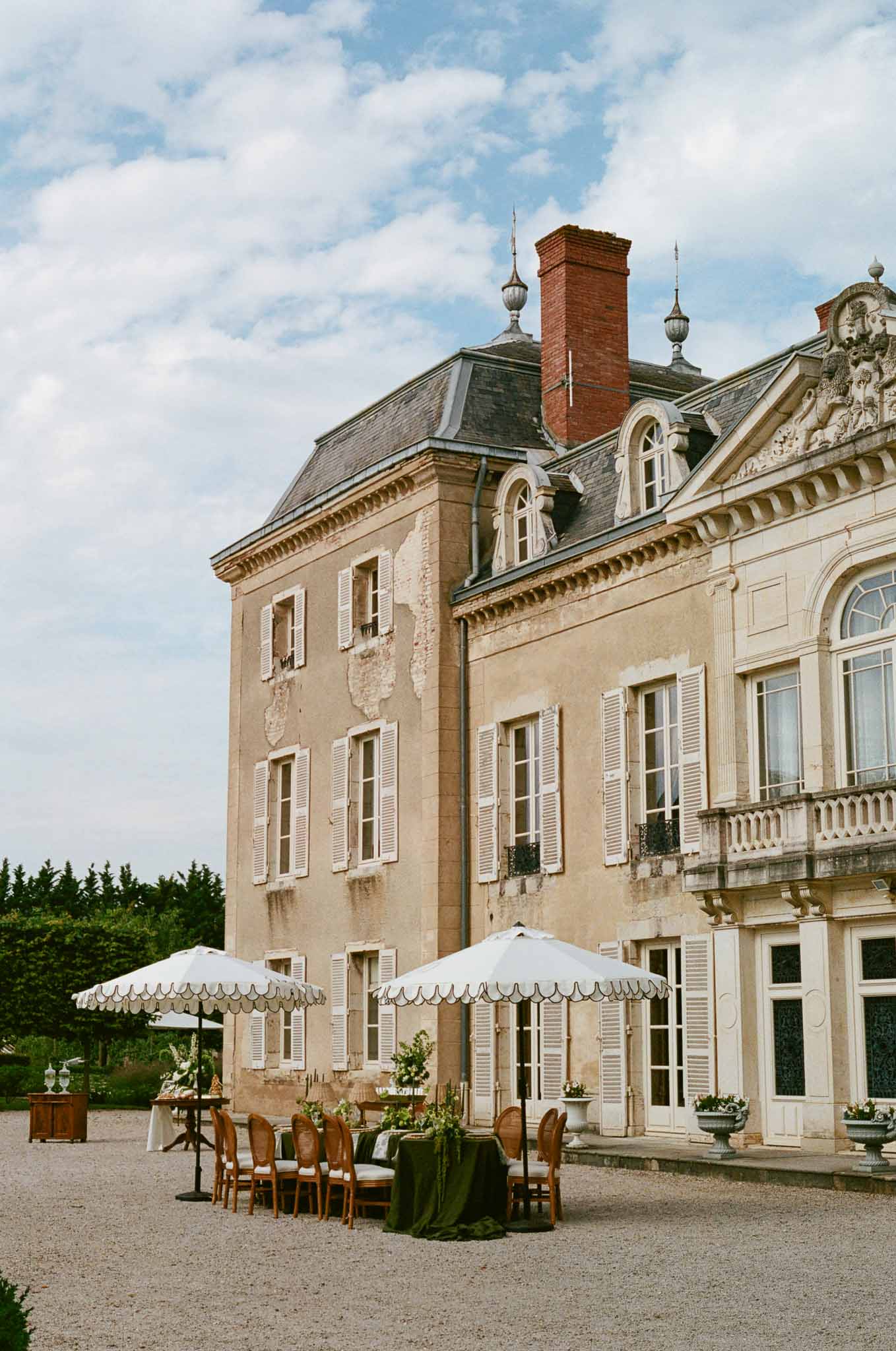 Outdoor reception setup in front of nineteenth-century château with classical architecture and formal grounds