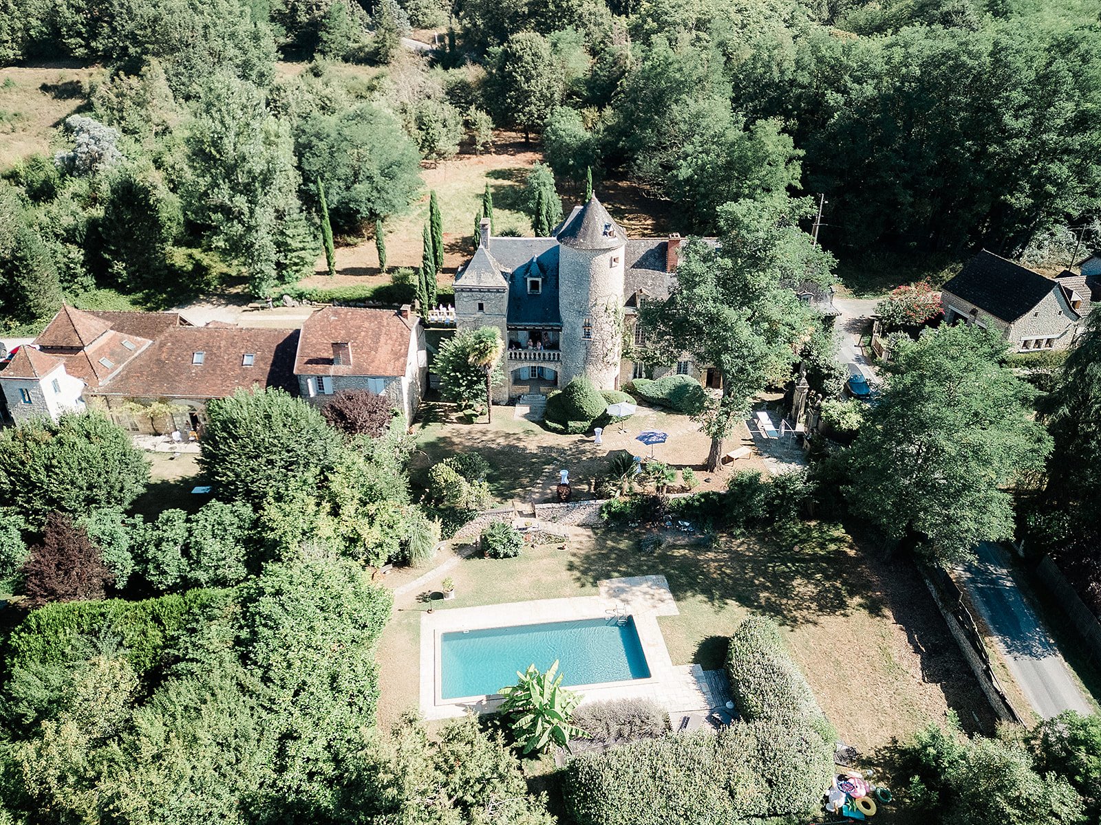 Aerial view of French château wedding venue with swimming pool and landscaped grounds