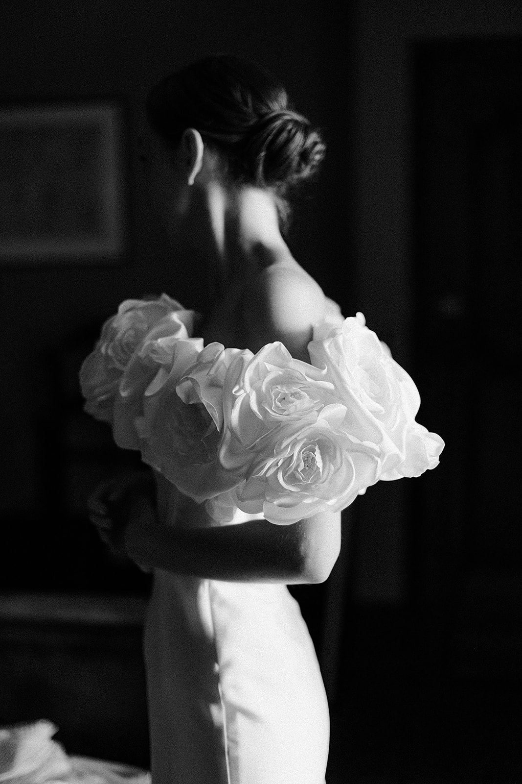 Bride in wedding dress holding rose bouquet in black and white portrait