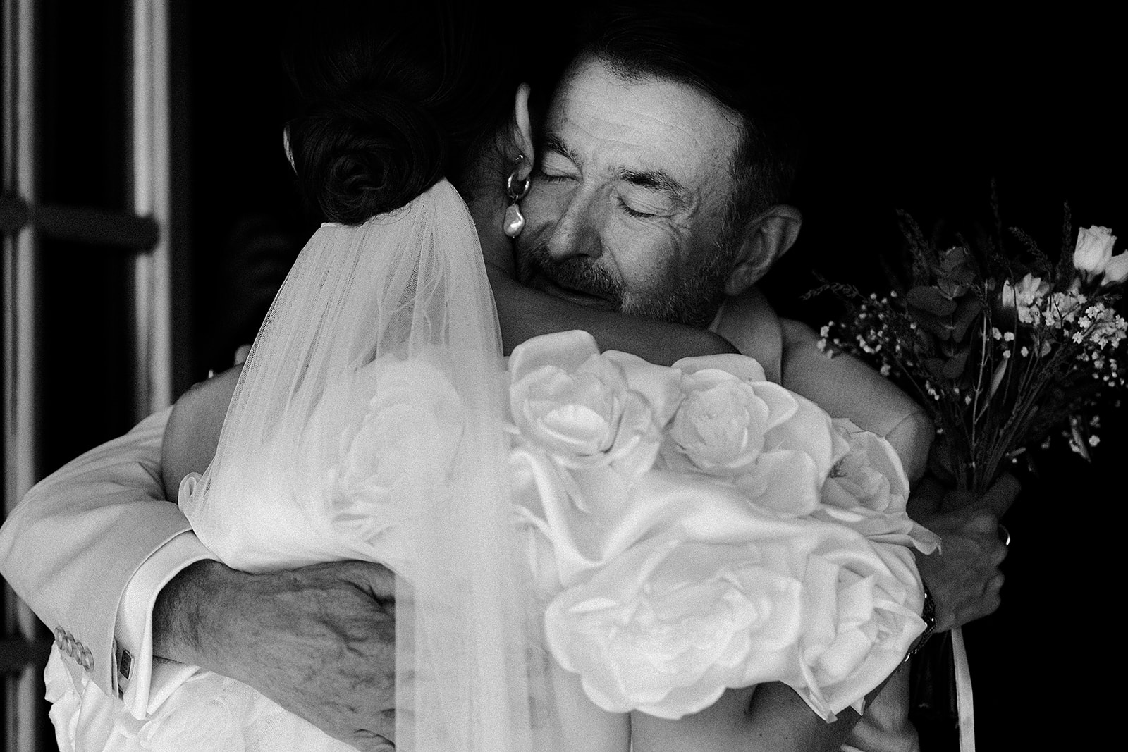 Groom carrying bride in intimate black and white portrait at wedding celebration