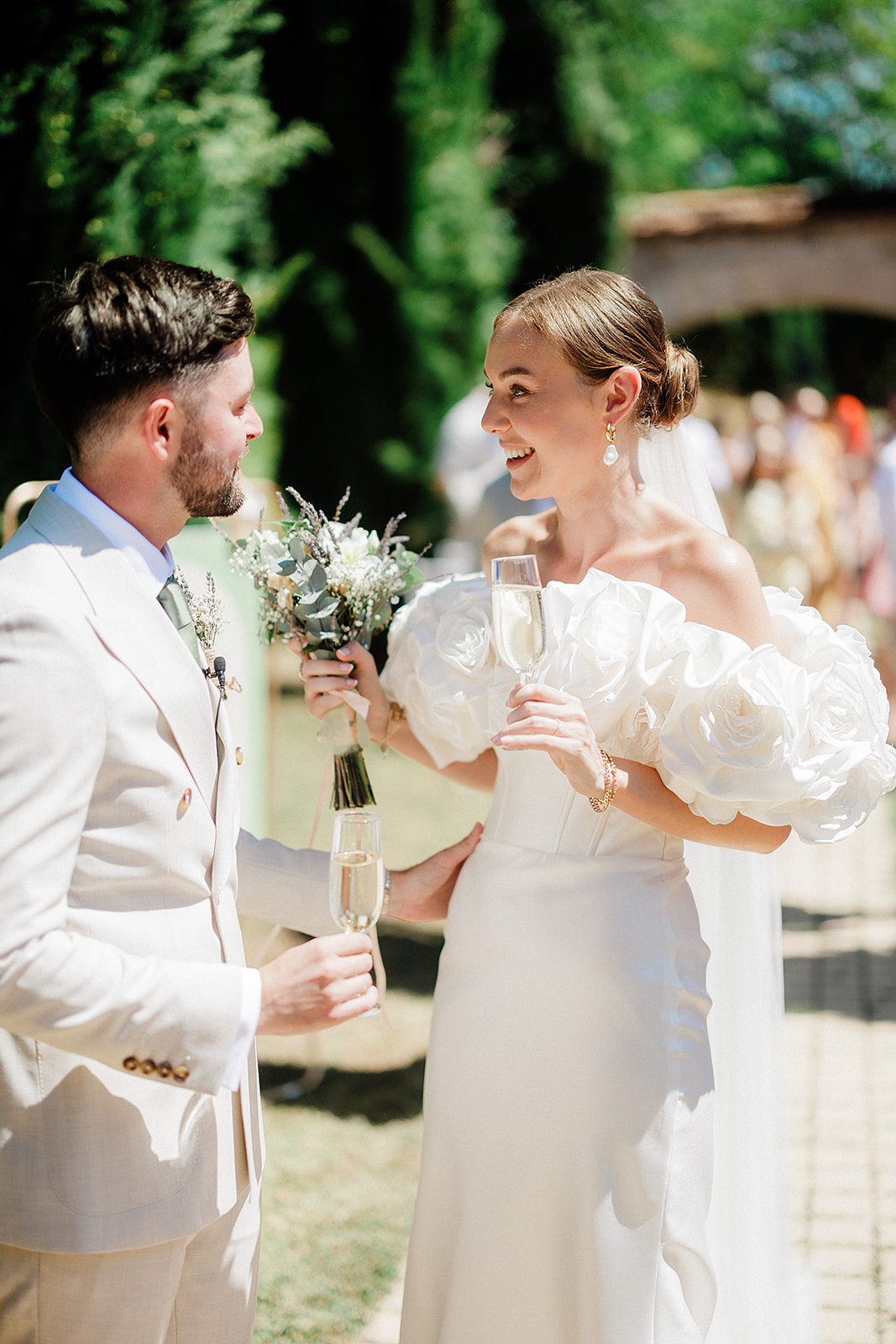 Bride and groom with champagne flutes during outdoor garden reception