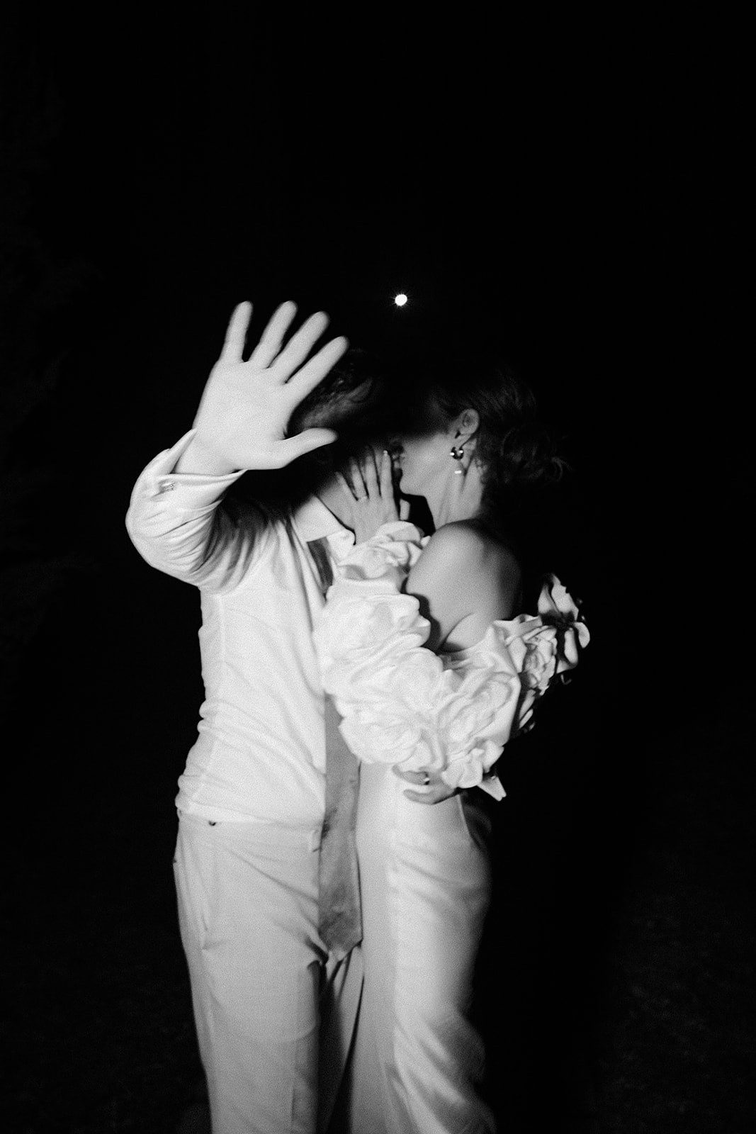 Black and white portrait of bride and groom during evening celebration with dramatic lighting