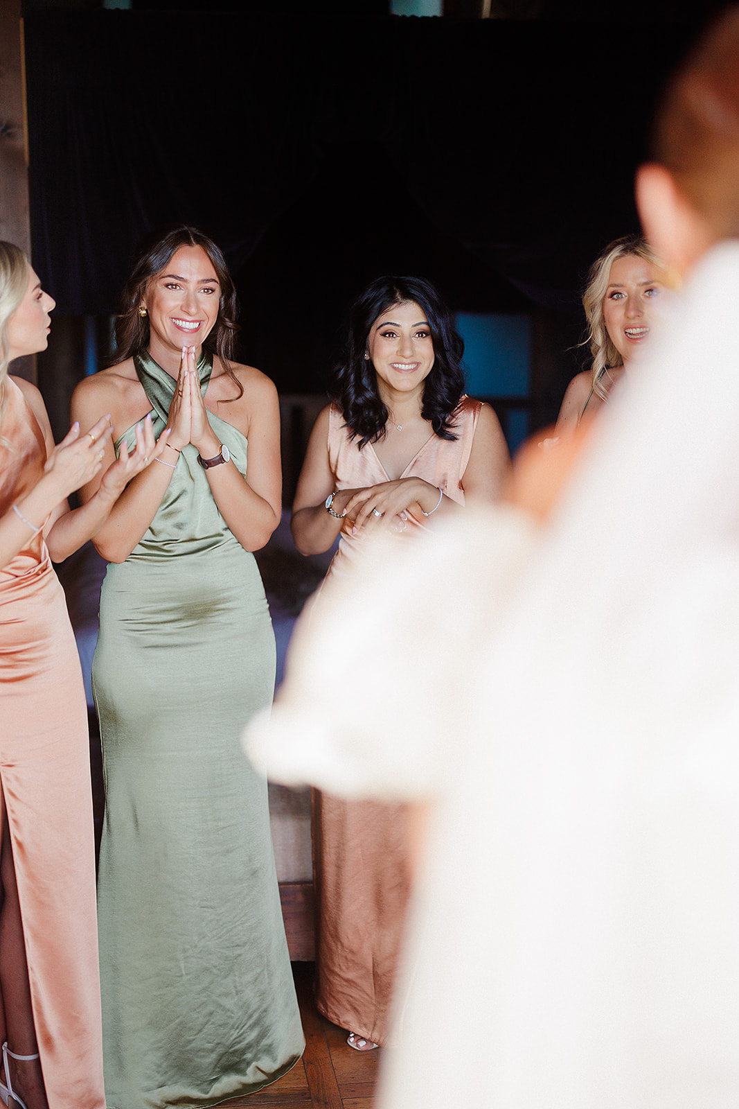 Bridesmaids and wedding guests celebrating on dance floor during evening reception