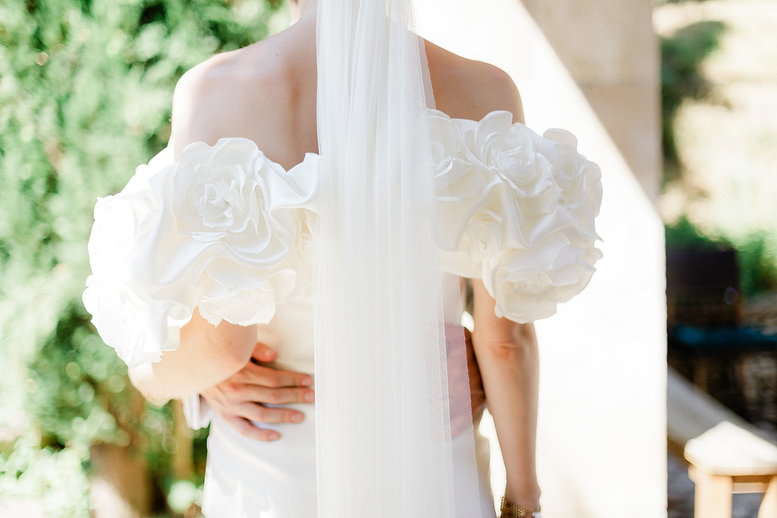 Bride holding white rose bouquet in ivory strapless dress at outdoor garden ceremony venue