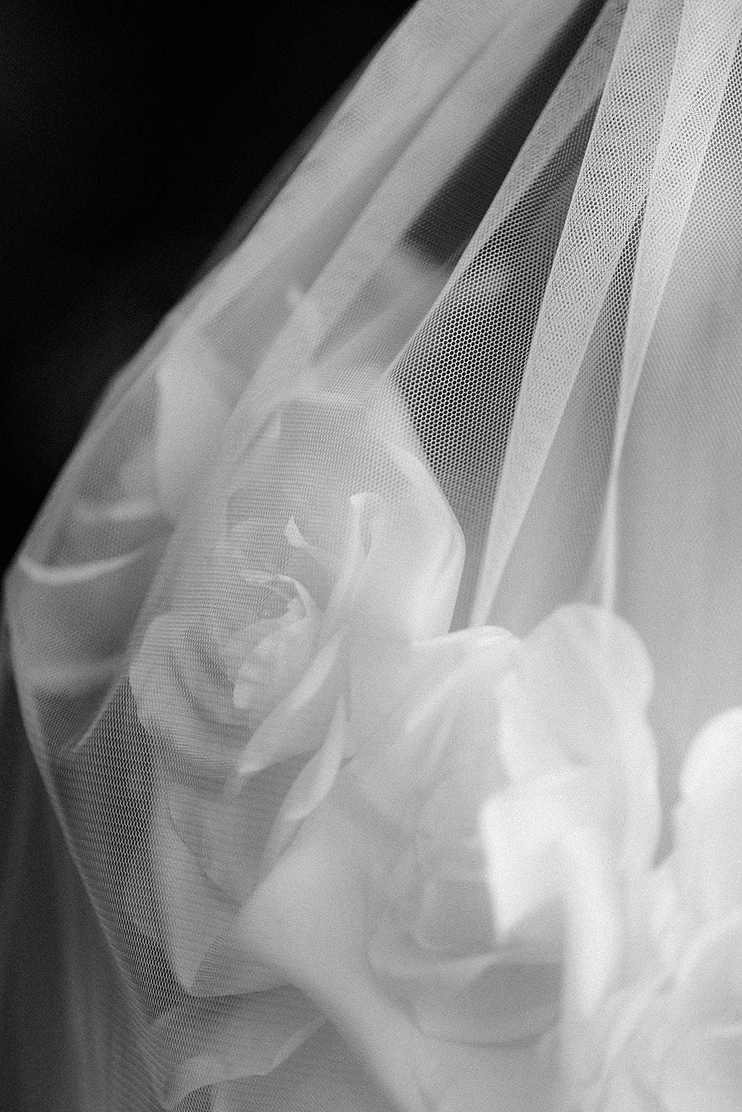 Close-up of bridal veil and dress fabric details in black and white