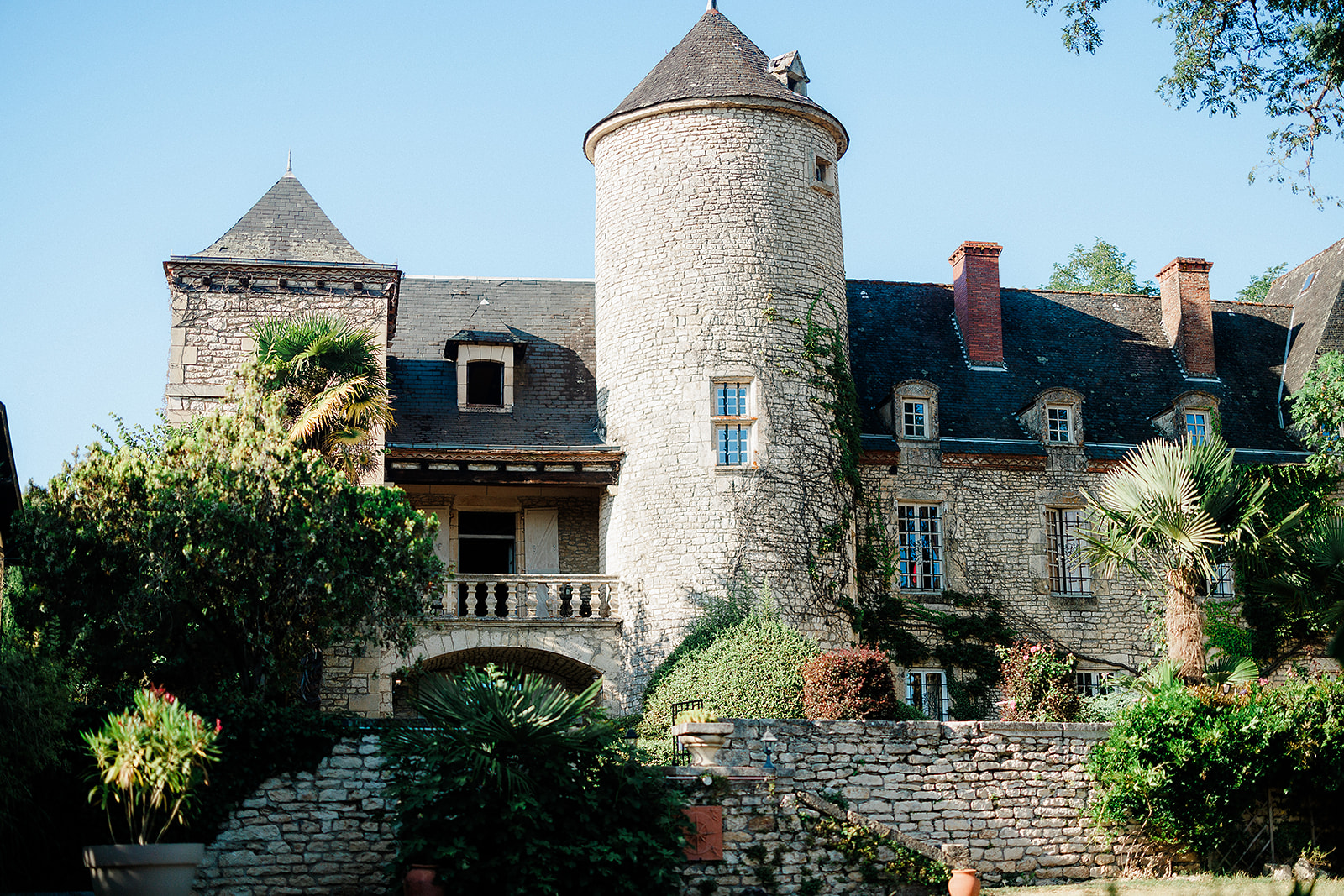 Historic stone château with conical towers and landscaped gardens at French wedding venue