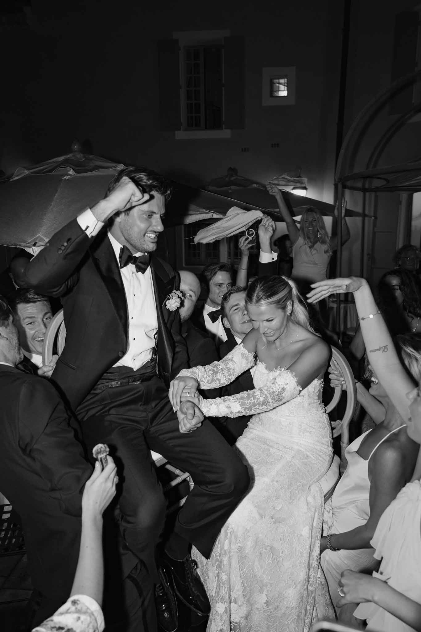 Bride and groom dancing surrounded by wedding guests during reception at indoor venue