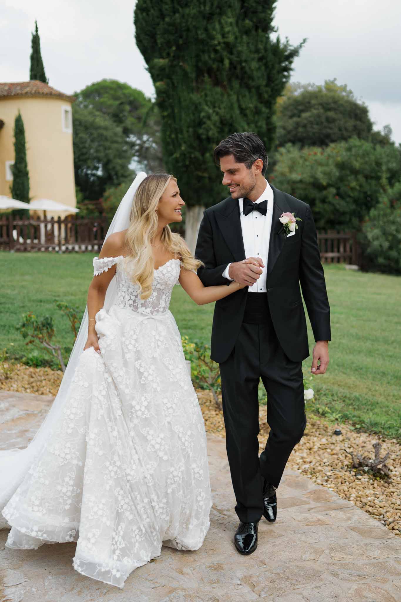 Bride and groom walking together on stone pathway at Tuscan villa wedding