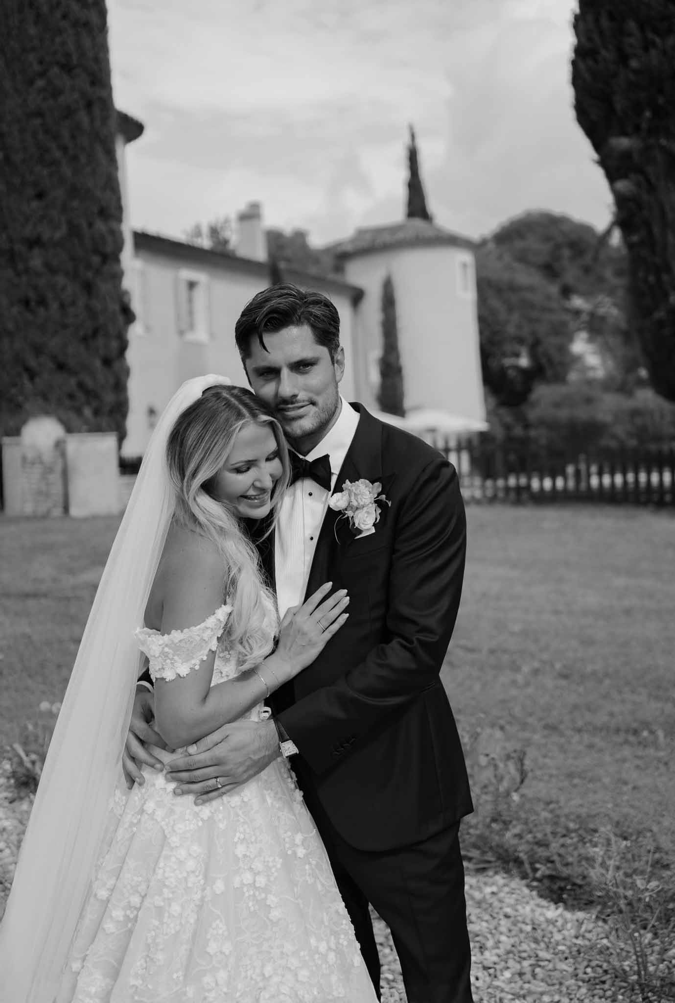 Black and white couple embracing before chateau tower bride in floral applique gown with cathedral veil