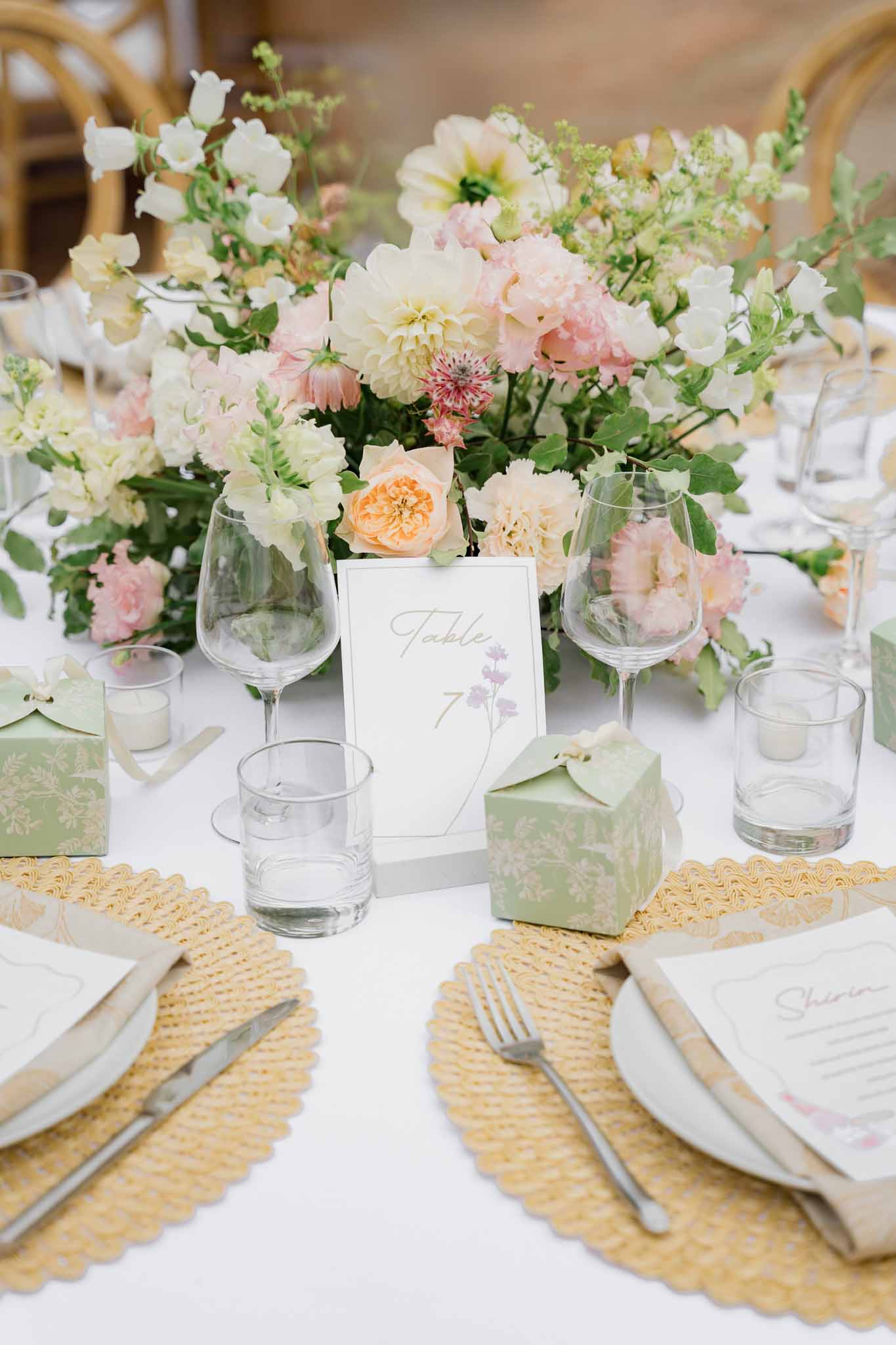 Wedding reception table setting with floral centerpiece and white linens