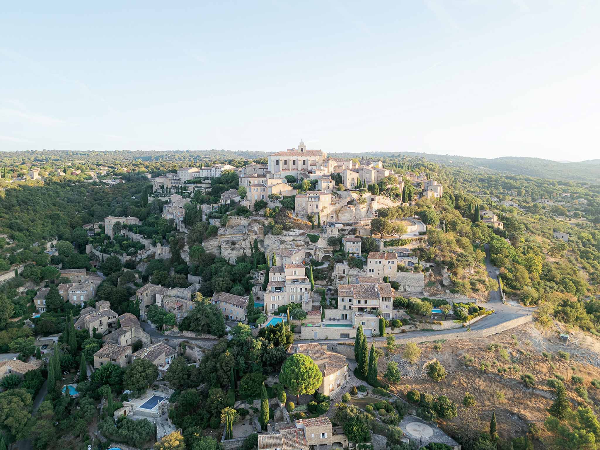 Aerial view of Provençal hilltop village with stone architecture and cypress trees for destination wedding venue