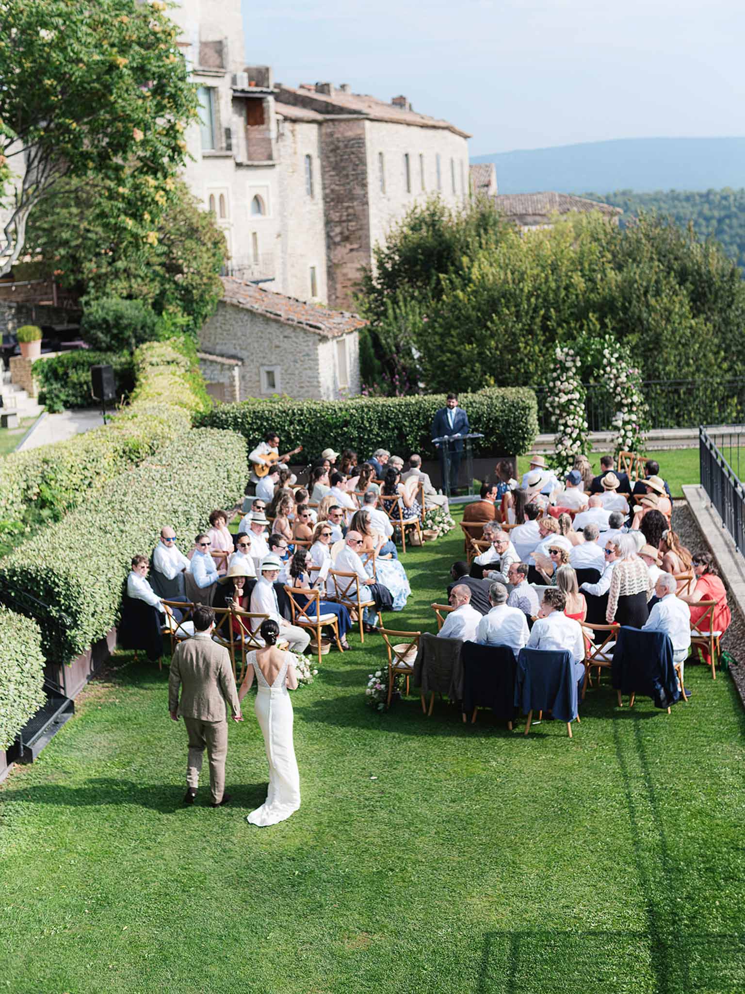 Outdoor wedding ceremony on terrace at historic stone villa with ivy-covered walls
