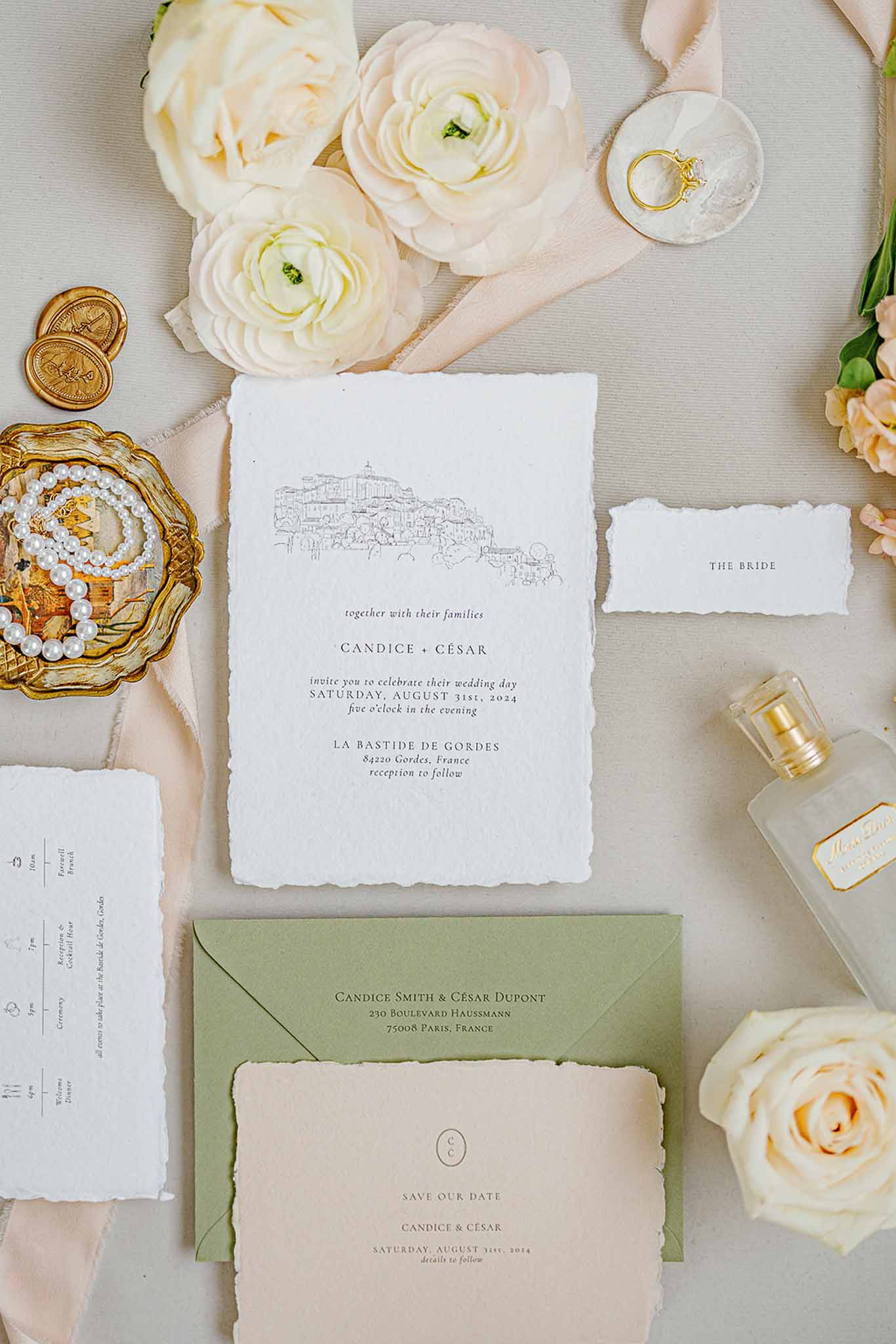 Wedding invitation flat lay with rings and flowers at French château wedding