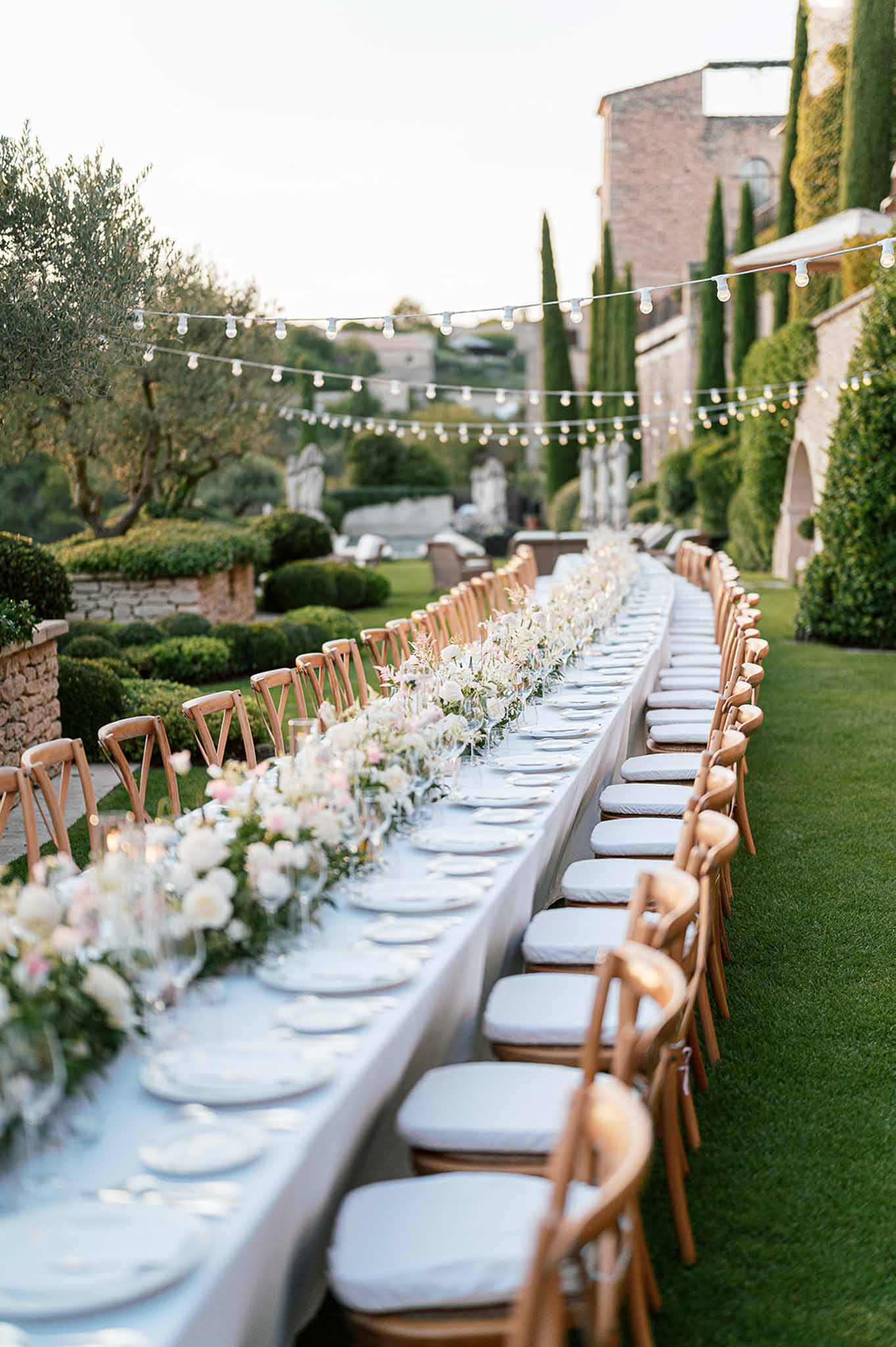 Elegant outdoor reception table setup in Mediterranean villa garden courtyard with string lights